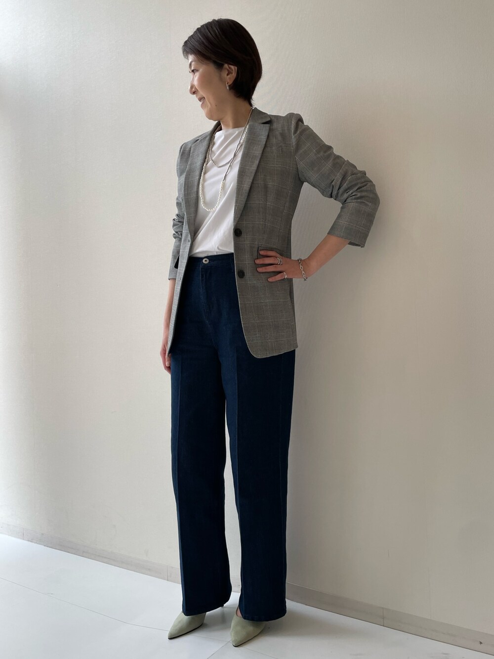 ベージュ系のテーラードジャケット、ブルー系のパンツを着用したレディースの冬コーディネートの2枚目の写真