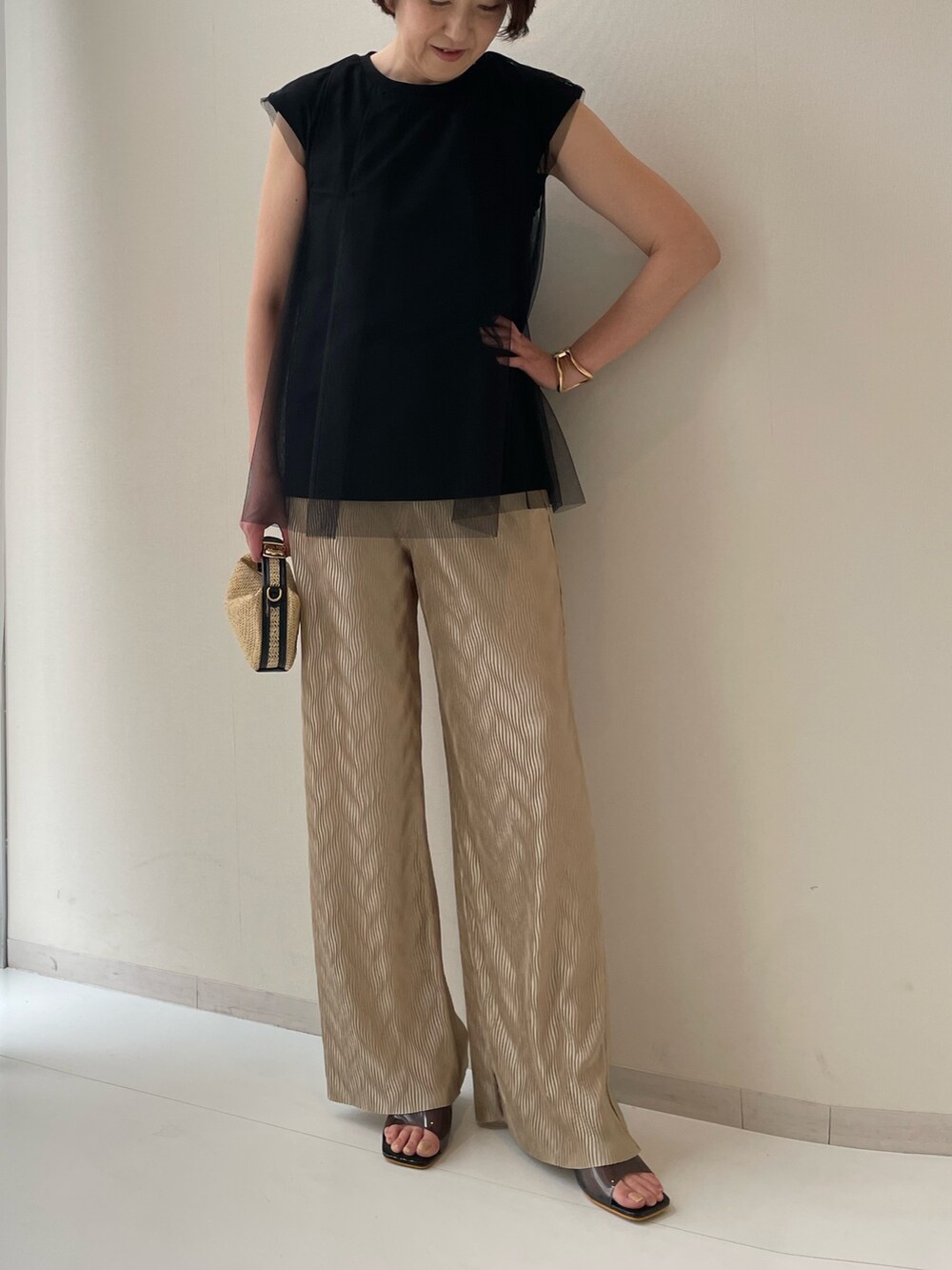 ブラック系のTシャツ/カットソー、ブラウン系のパンツを着用したレディースの春コーディネートの2枚目の写真