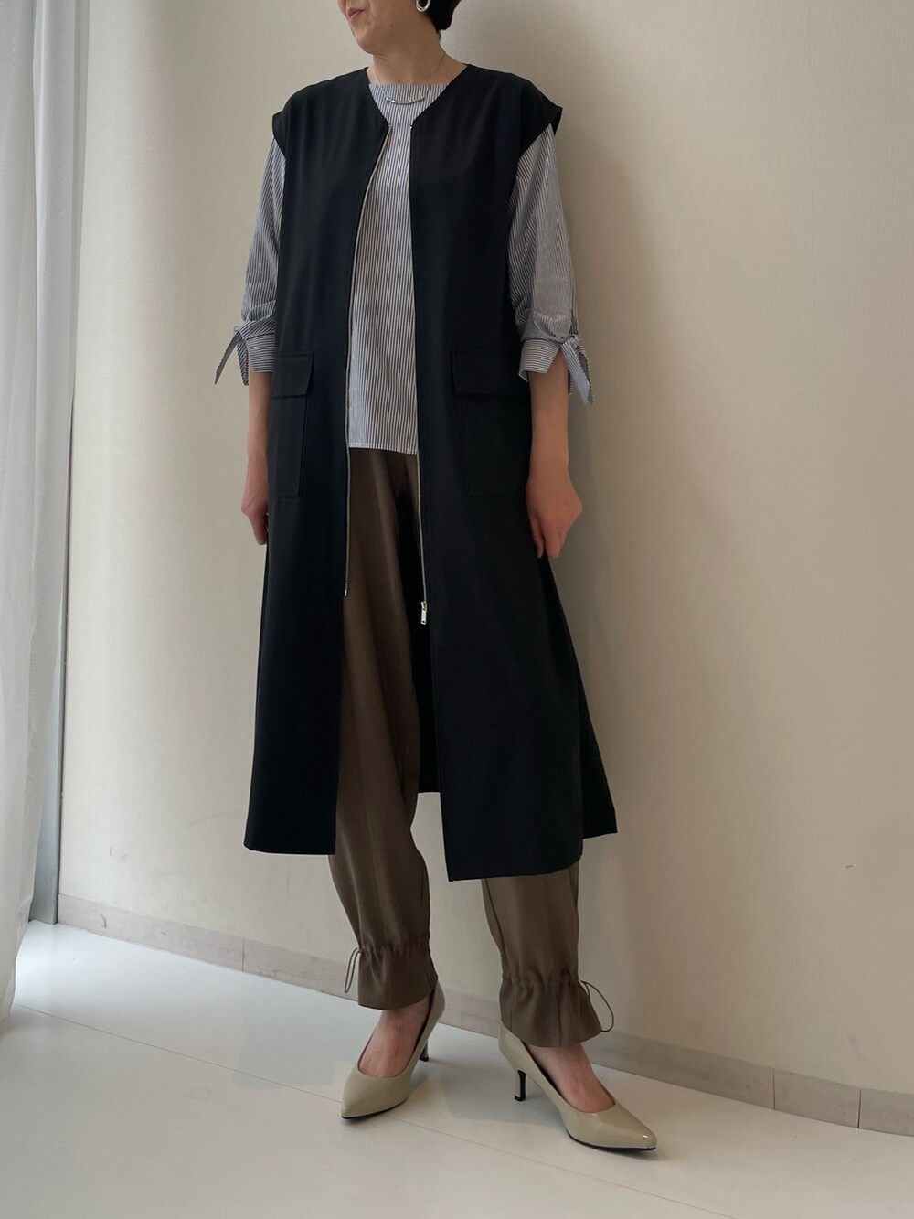 ブラック系のワンピース、ブルー系のシャツ/ブラウス、ブラウン系のパンツを着用したレディースの春コーディネートの2枚目の写真