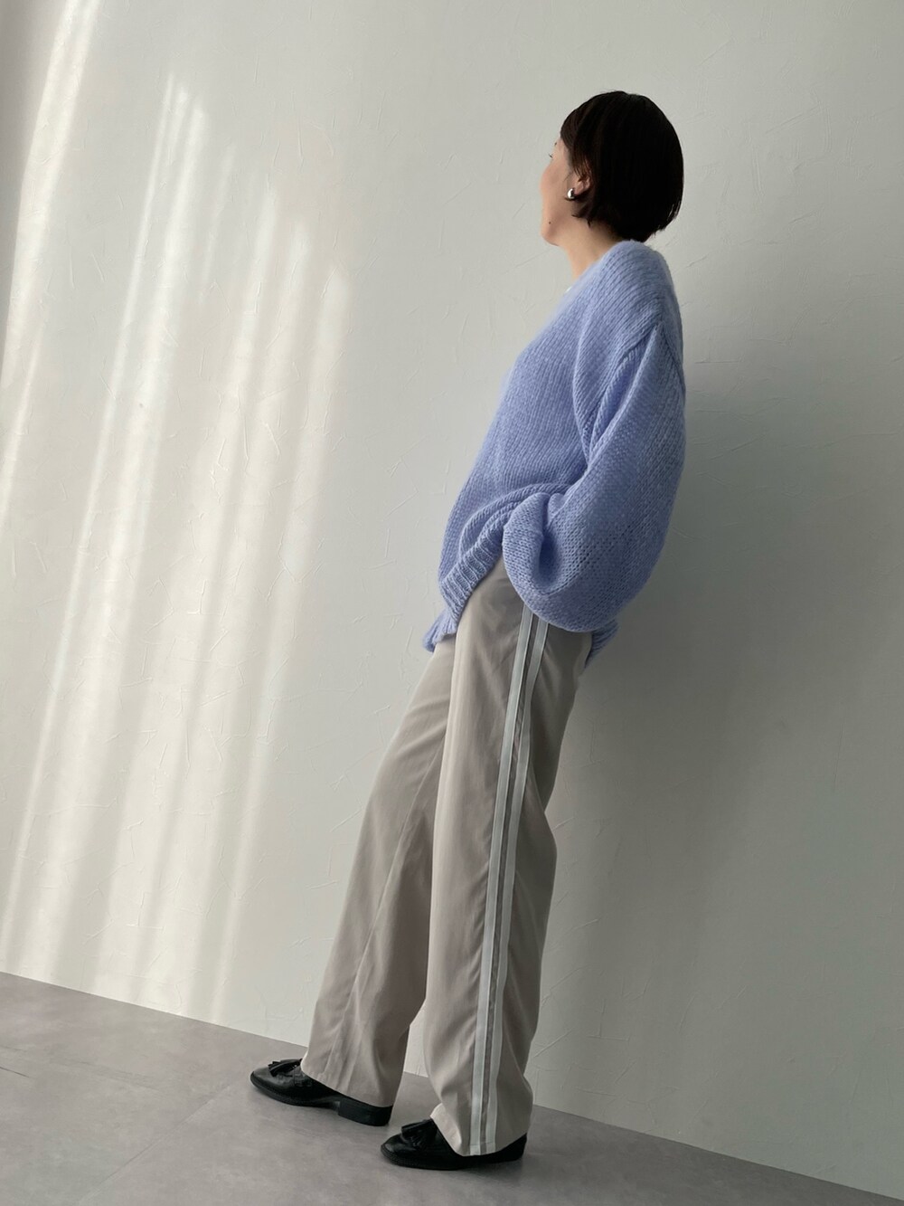 ブルー系のニット/セーター、ベージュ系のパンツを着用したレディースの冬コーディネートの2枚目の写真