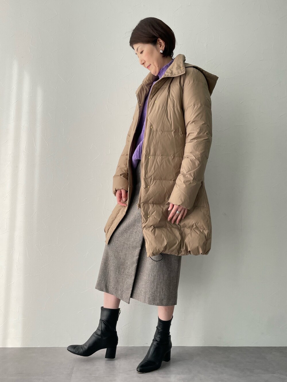 ブラウン系のスカート、ブラウン系のダウンジャケット/コート、パープル系のニット/セーターを着用したレディースの冬コーディネートの2枚目の写真