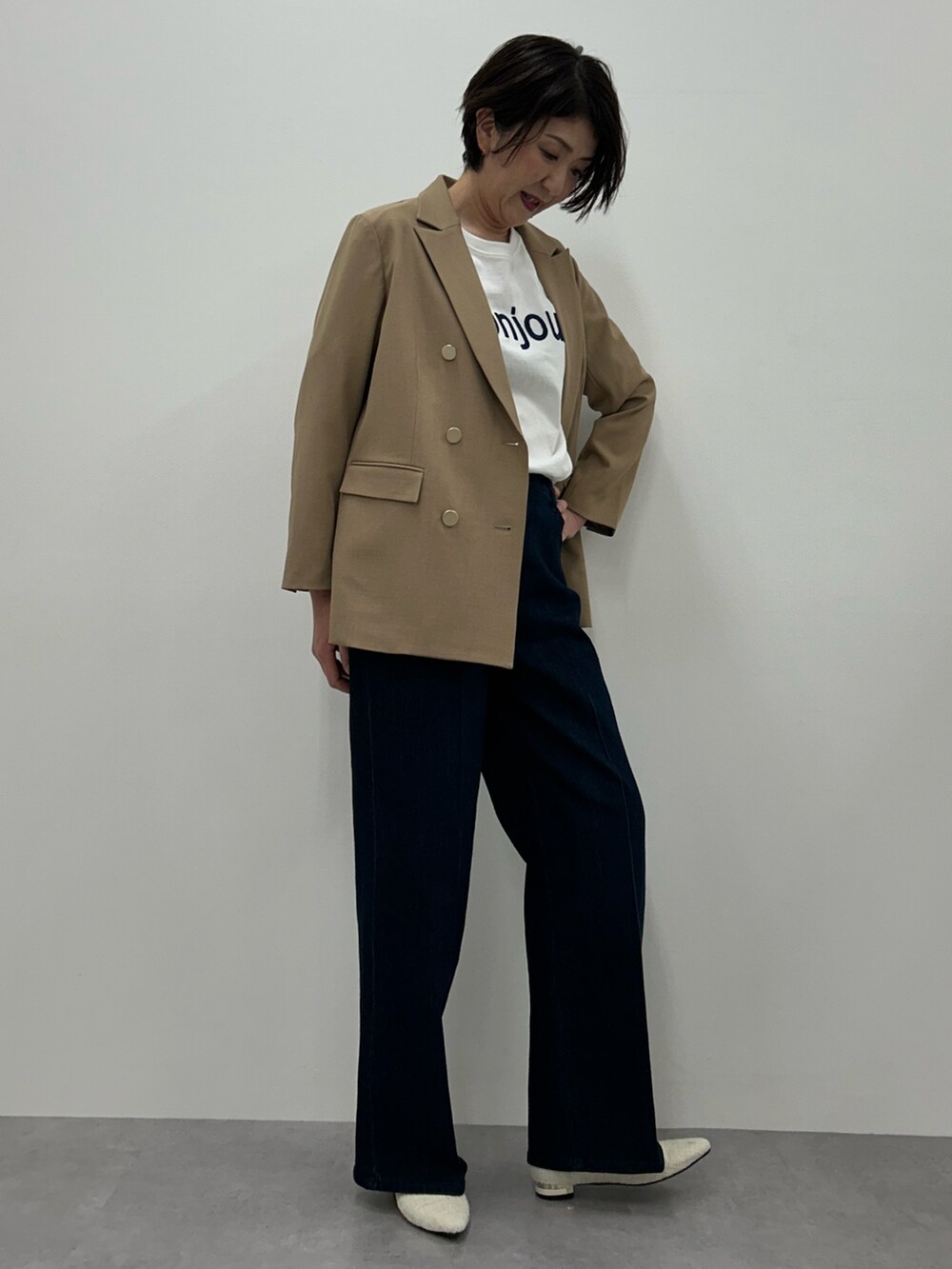 ブラウン系のジャケット/アウター、ブルー系のパンツ、ホワイト系のTシャツ/カットソーを着用したレディースの冬コーディネートの2枚目の写真