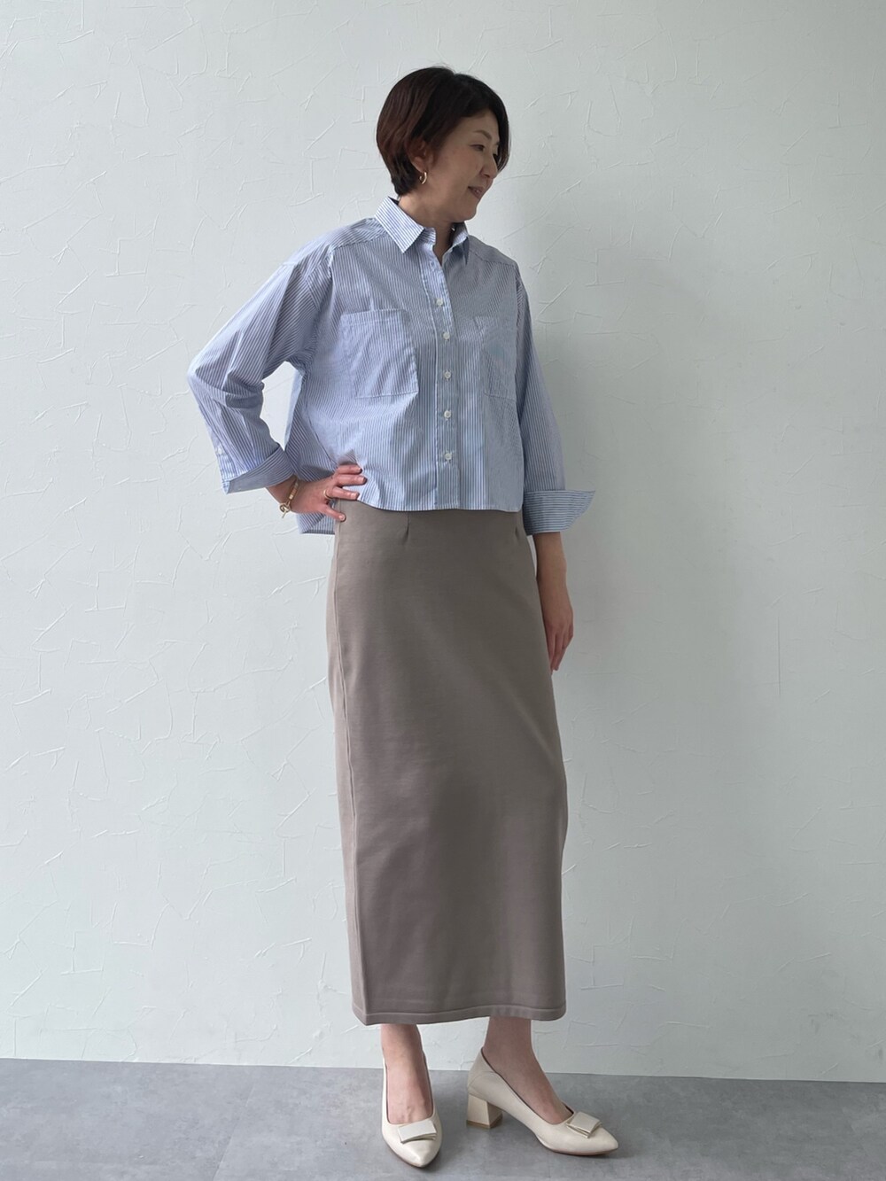 ブルー系のシャツ/ブラウス、ベージュ系のスカートを着用したレディースの冬コーディネートの2枚目の写真