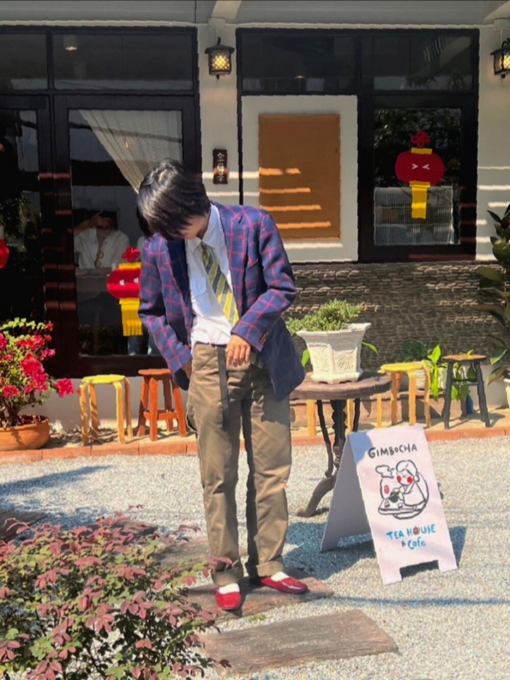 ブルー系のテーラードジャケット、ブラウン系のチノパンツ、レッド系のバレエシューズを着用したレディースの冬コーディネートの2枚目の写真