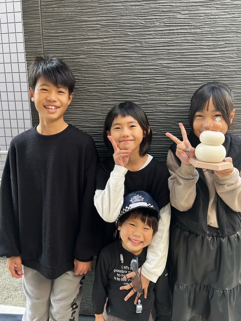 ブラック系のベスト、ベージュ系のワンピース、ブラック系のスニーカーを着用したレディースの冬コーディネートの4枚目の写真