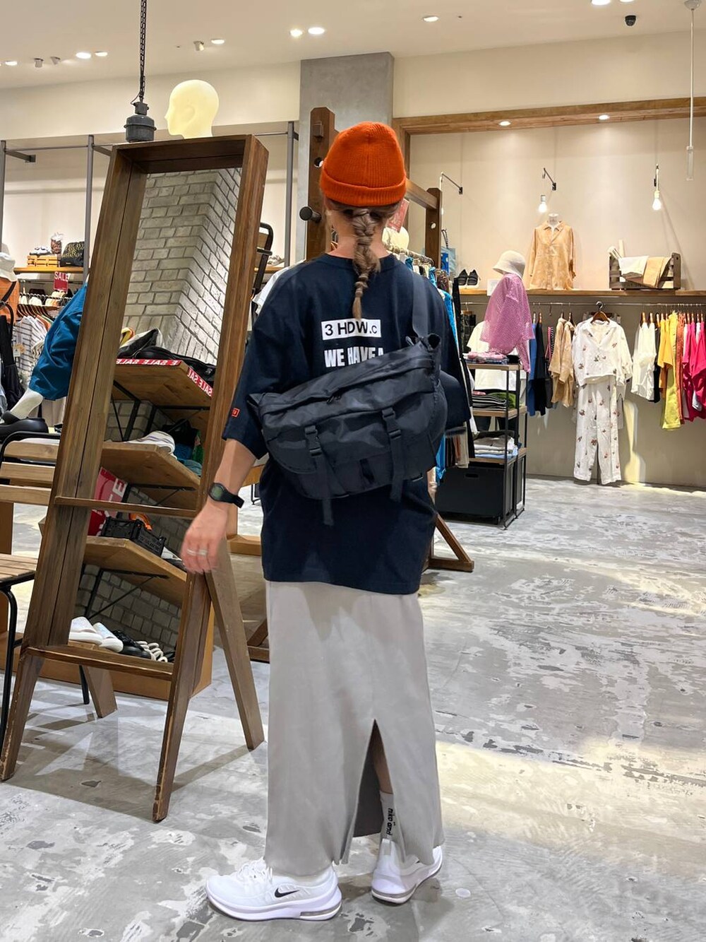 ブラック系のショルダーバッグ、グレー系のスカート、ブラック系のTシャツ/カットソーを着用したレディースの夏コーディネートの4枚目の写真
