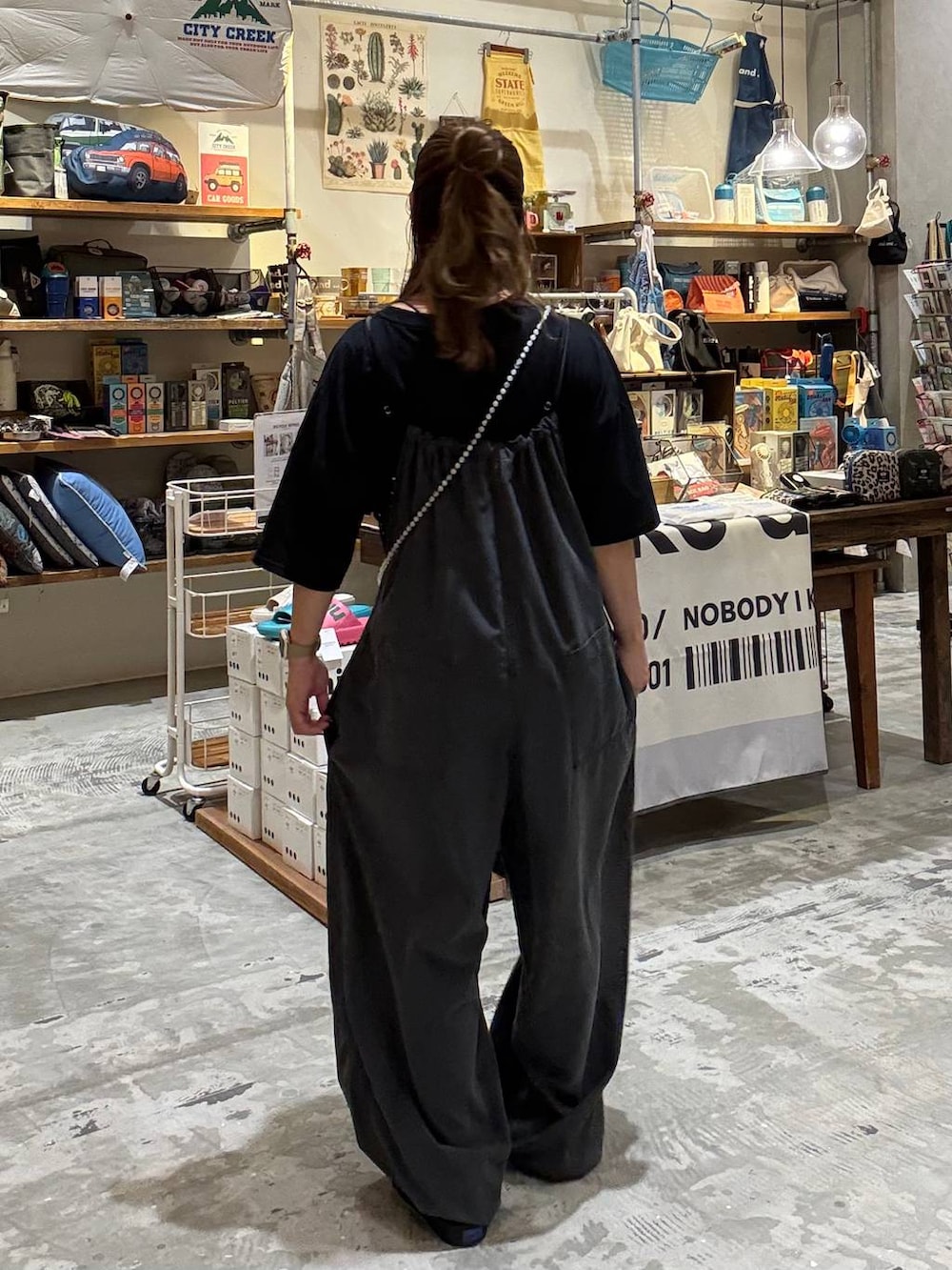 ブラック系のTシャツ/カットソー、グレー系のサロペット/オーバーオール、ブラック系のショルダーバッグを着用したレディースの夏コーディネートの4枚目の写真