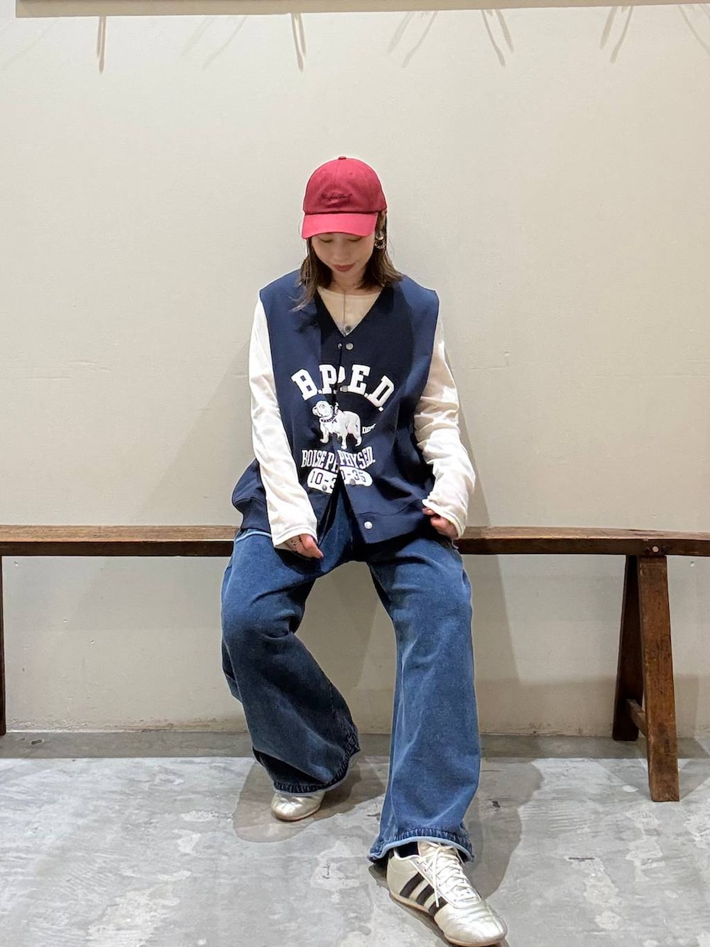 ゴールド系のスニーカー、ベージュ系のTシャツ/カットソー、ブルー系のベストを着用したレディースの冬コーディネートの2枚目の写真