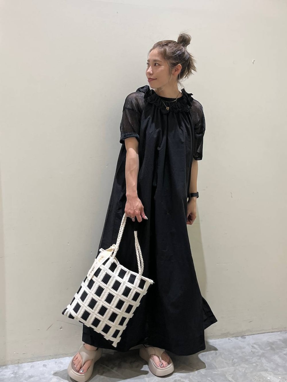 ベージュ系のサンダル、ブラック系のワンピース、ブラック系のトートバッグを着用したレディースの春コーディネートの9枚目の写真