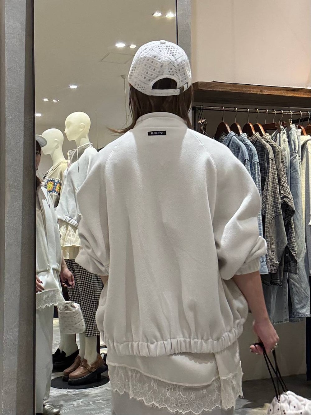 ゴールド系のスニーカー、ホワイト系のショルダーバッグ、ベージュ系のブルゾンを着用したレディースの春コーディネートの7枚目の写真