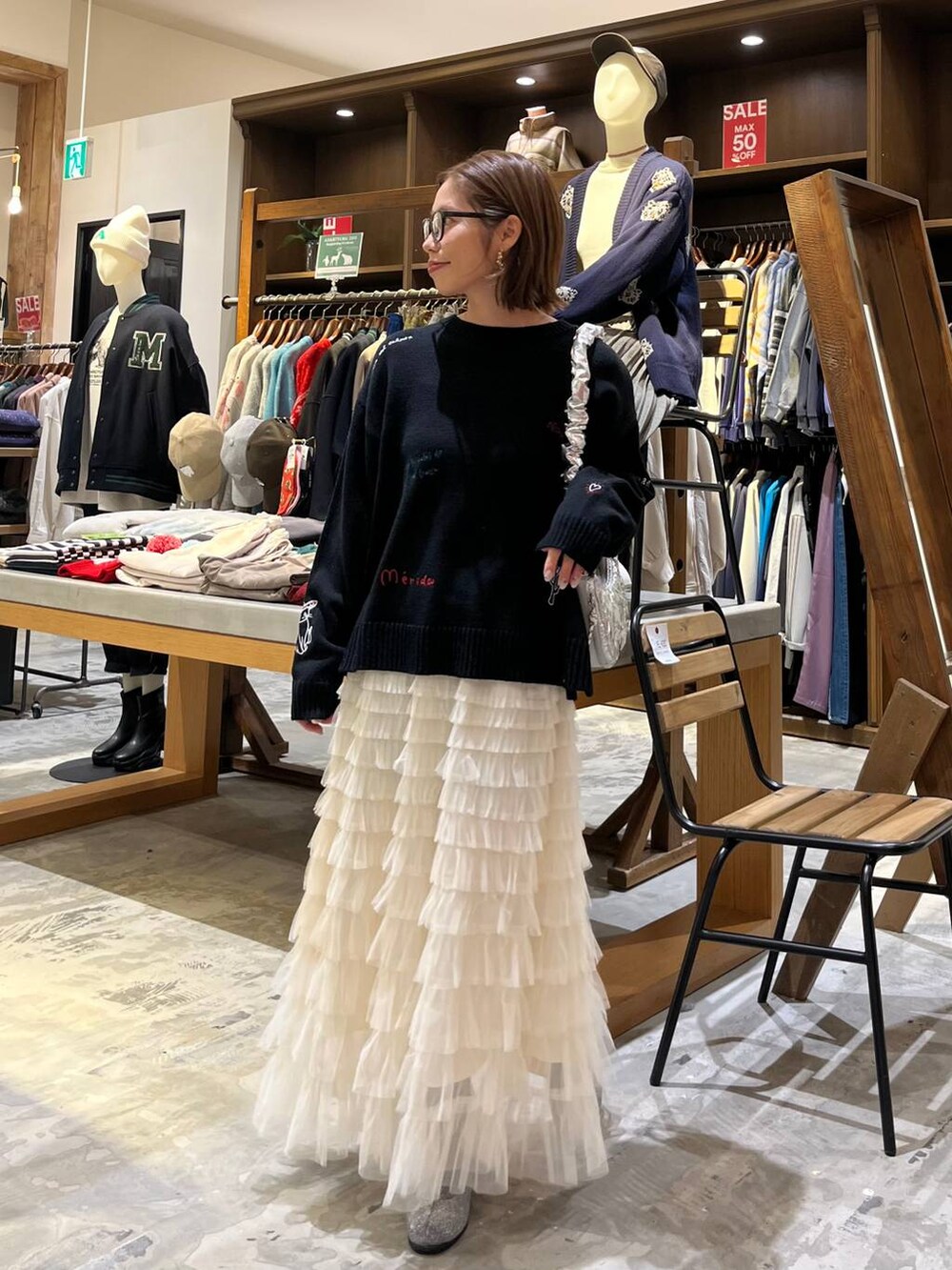 グレー系のブーツ、ホワイト系のスカート、シルバー系のショルダーバッグを着用したレディースの冬コーディネートの4枚目の写真