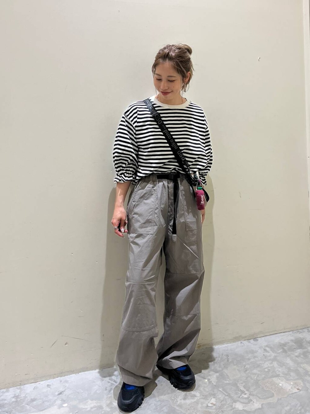 グレー系のその他パンツ、ブラック系のスニーカー、ホワイト系のTシャツ/カットソーを着用したレディースの春コーディネートの5枚目の写真