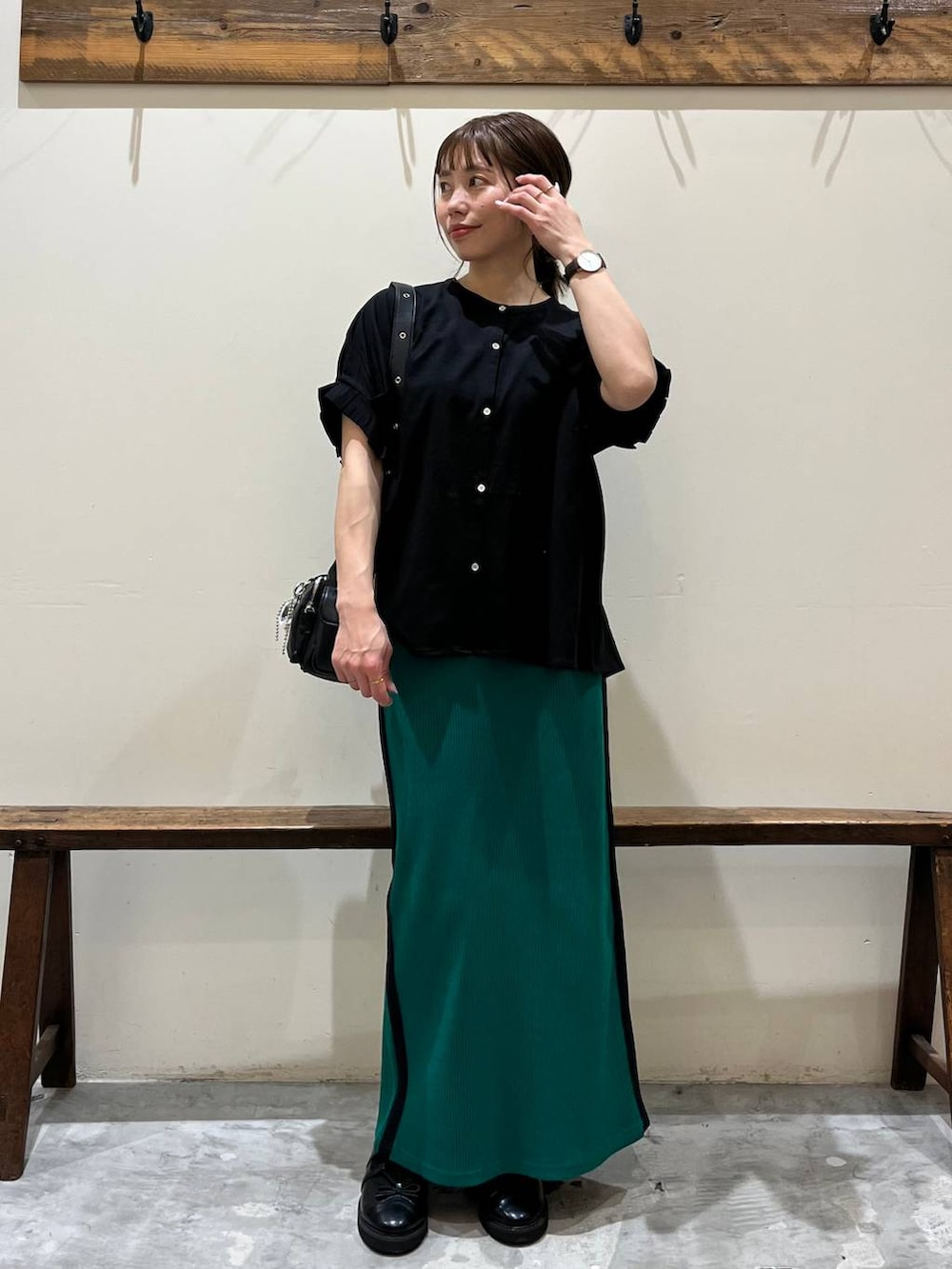 グリーン系のスカート、ブラック系のショルダーバッグ、ブラック系のバレエシューズを着用したレディースの春コーディネートの9枚目の写真
