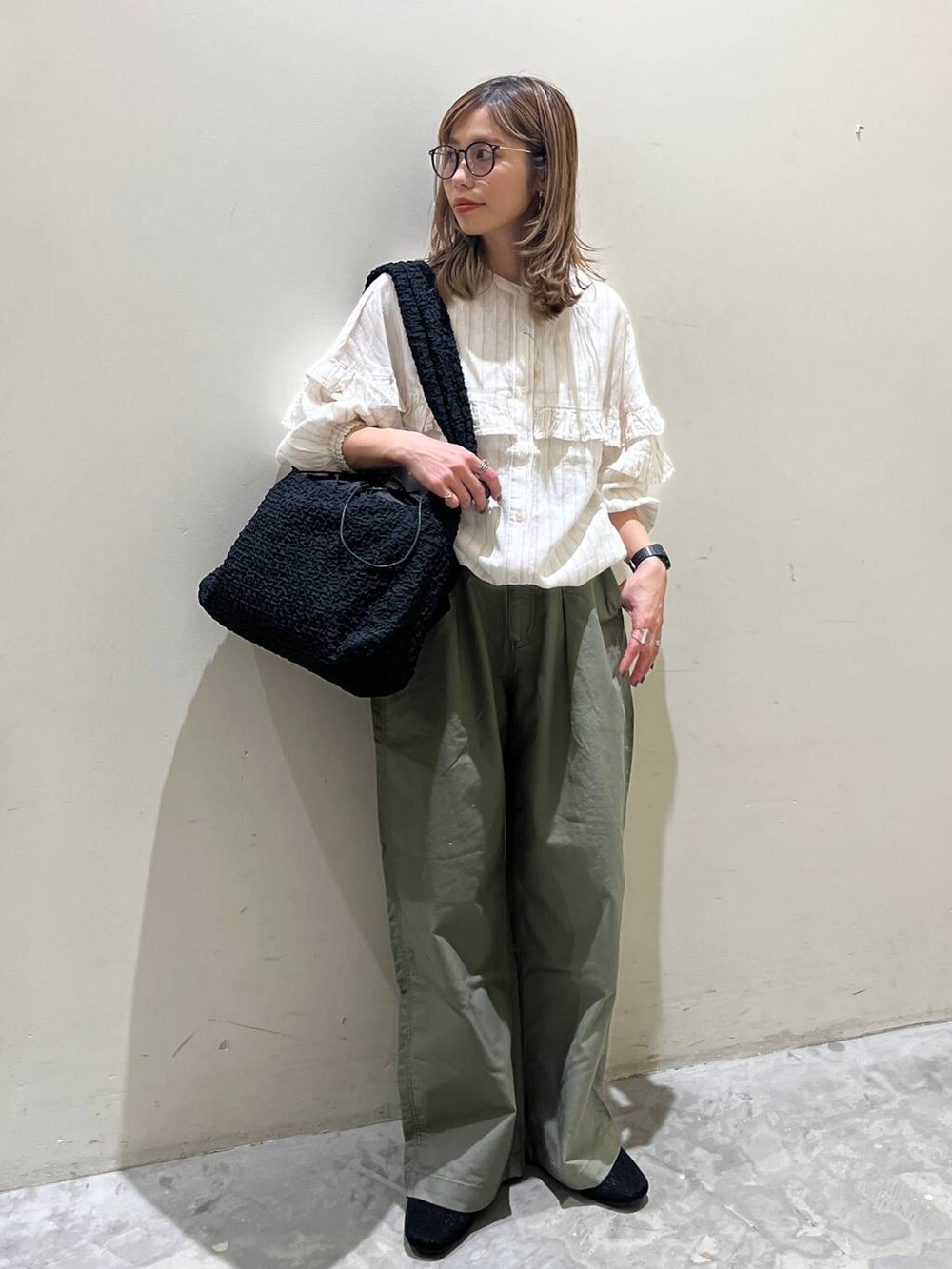 ブラック系のショルダーバッグ、ブラック系のその他シューズ、ベージュ系のシャツ/ブラウスを着用したレディースの春コーディネートの7枚目の写真