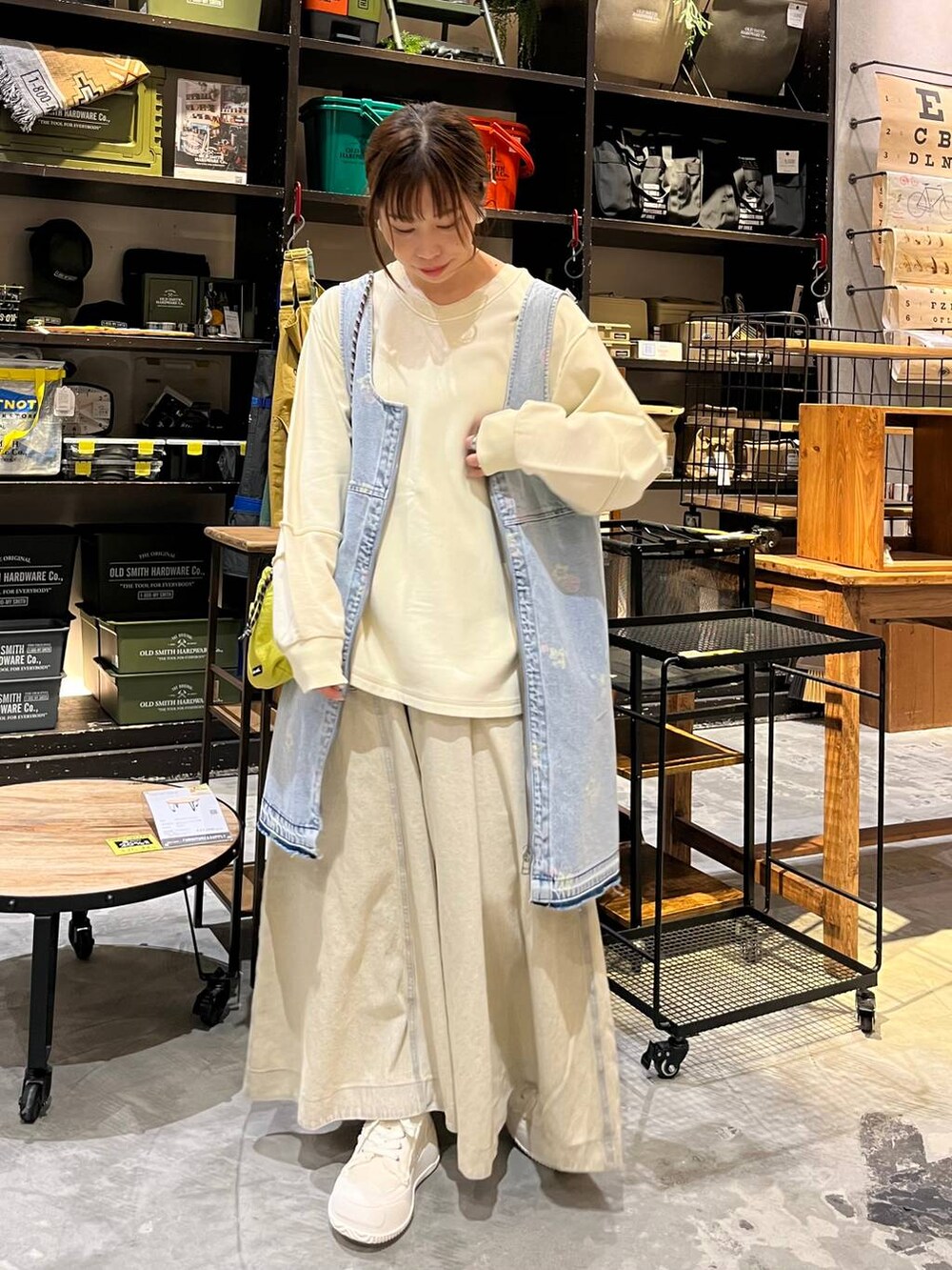 イエロー系のショルダーバッグ、ブルー系のドレス、ベージュ系のスニーカーを着用したレディースの冬コーディネートの2枚目の写真