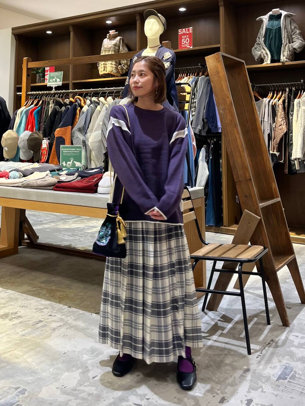 パープル系のニット/セーター、ベージュ系のスカート、その他のパンプスを着用したレディースの冬コーディネートの7枚目の写真