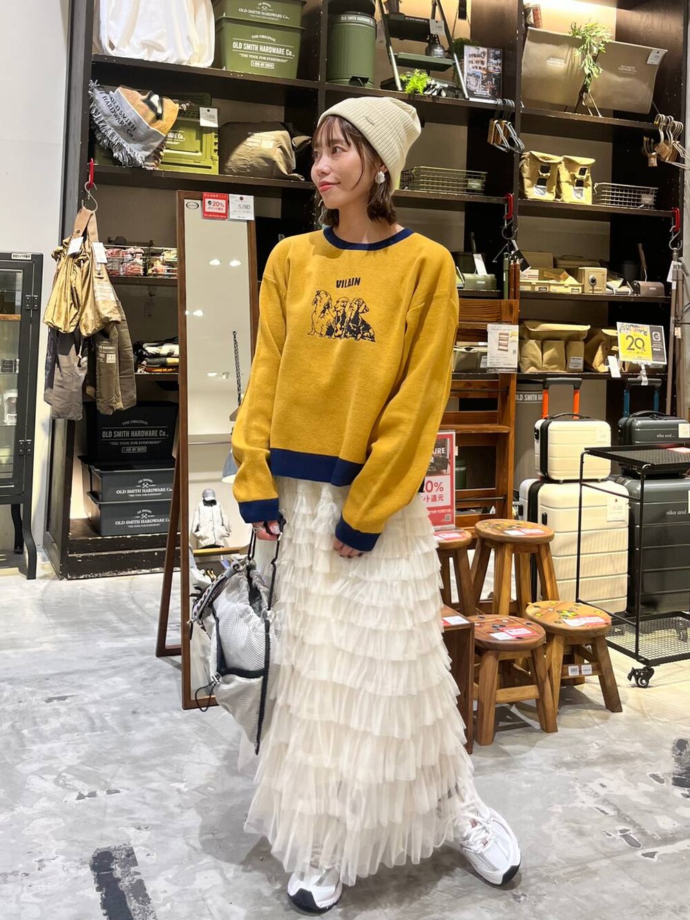 ホワイト系のスニーカー、グレー系のショルダーバッグ、ホワイト系のスカートを着用したレディースの秋コーディネートの6枚目の写真