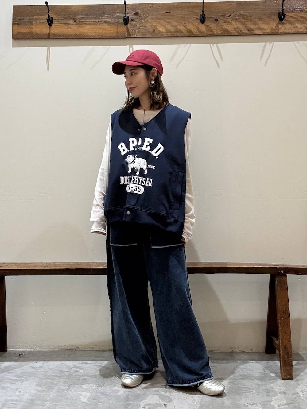 ゴールド系のスニーカー、ベージュ系のTシャツ/カットソー、ブルー系のベストを着用したレディースの冬コーディネートの5枚目の写真