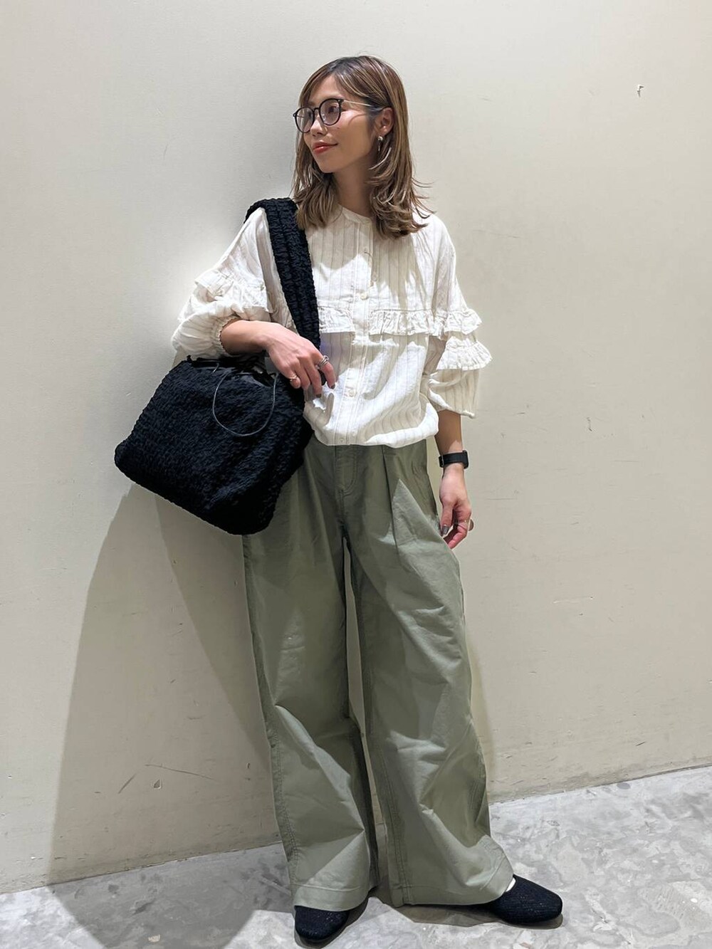 ブラック系のショルダーバッグ、ブラック系のその他シューズ、ベージュ系のシャツ/ブラウスを着用したレディースの春コーディネートの10枚目の写真