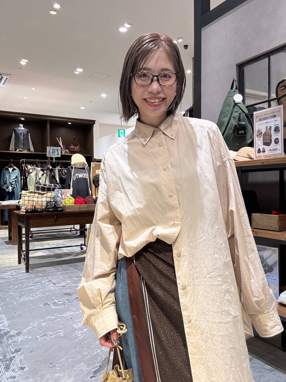 ベージュ系のシャツ/ブラウス、イエロー系のモカシン/デッキシューズ、ベージュ系のショルダーバッグを着用したレディースの秋コーディネートの3枚目の写真