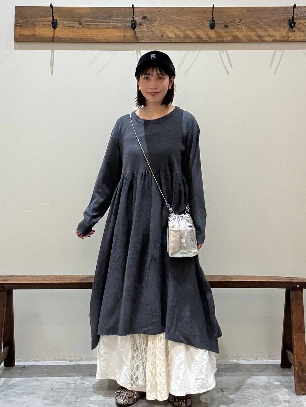 シルバー系のショルダーバッグ、グレー系のワンピース、ベージュ系のスカートを着用したレディースの秋コーディネートの6枚目の写真