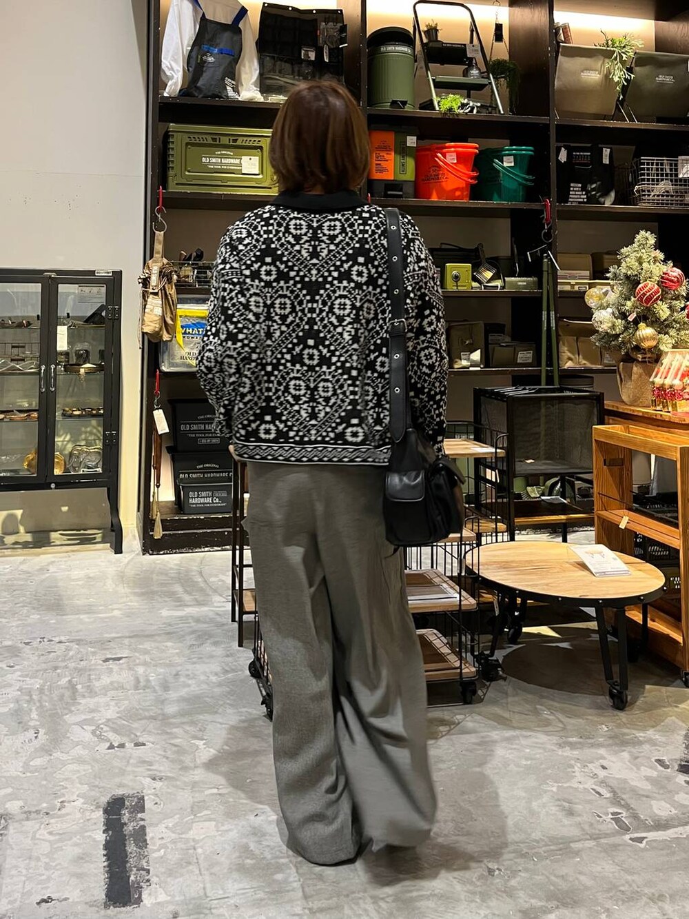 グレー系のその他パンツ、ベージュ系のTシャツ/カットソー、ブラック系のブーツを着用したレディースの冬コーディネートの2枚目の写真