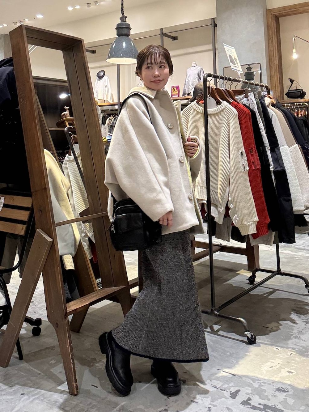 ベージュ系のブルゾン、イエロー系のニット/セーター、ホワイト系のスカートを着用したレディースの冬コーディネートの3枚目の写真