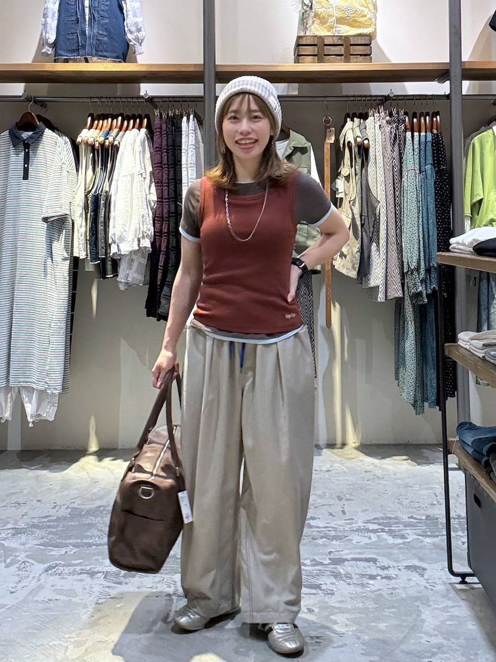 ゴールド系のスニーカー、ブラウン系のTシャツ/カットソー、ブラウン系のボストンバッグを着用したレディースの春コーディネートの2枚目の写真
