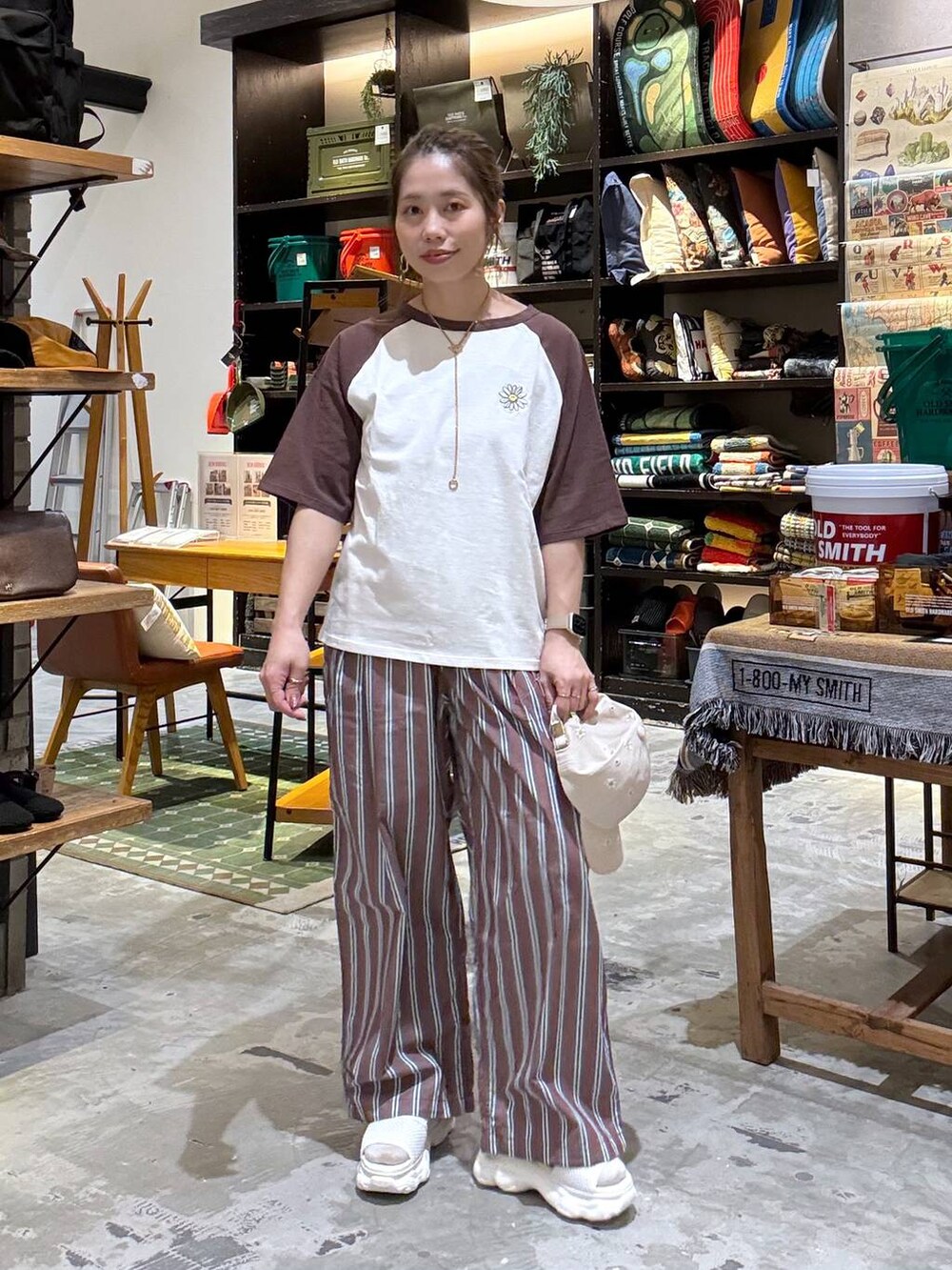 ブラウン系のその他パンツ、ベージュ系のTシャツ/カットソー、ベージュ系のサンダルを着用したレディースの春コーディネートの2枚目の写真