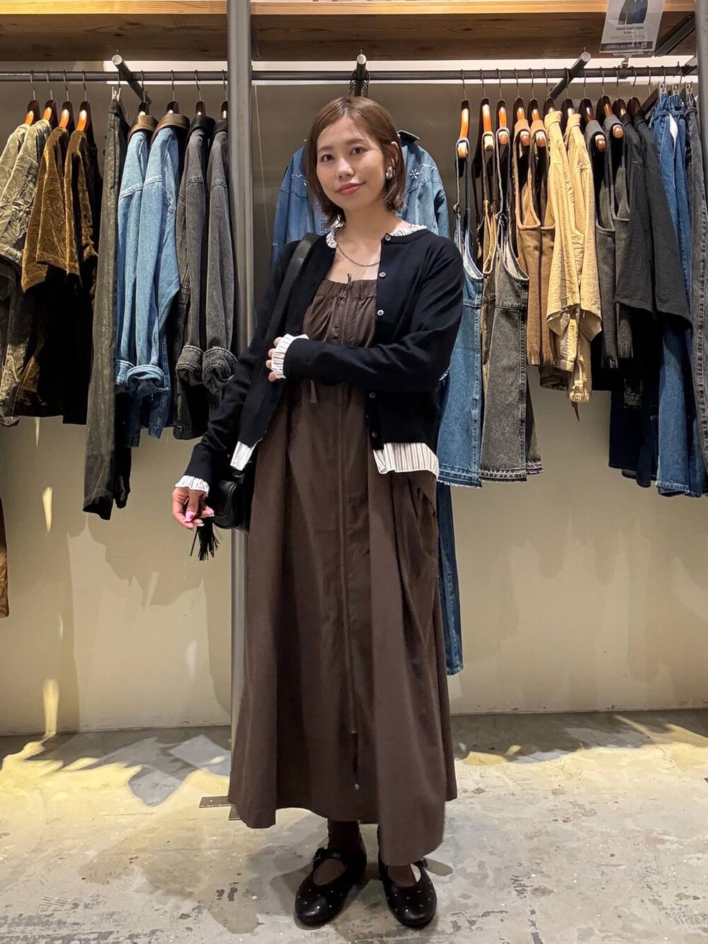 ブラック系のパンプス、ブラック系のカーディガン/ボレロ、ブラック系のショルダーバッグを着用したレディースの秋コーディネートの2枚目の写真