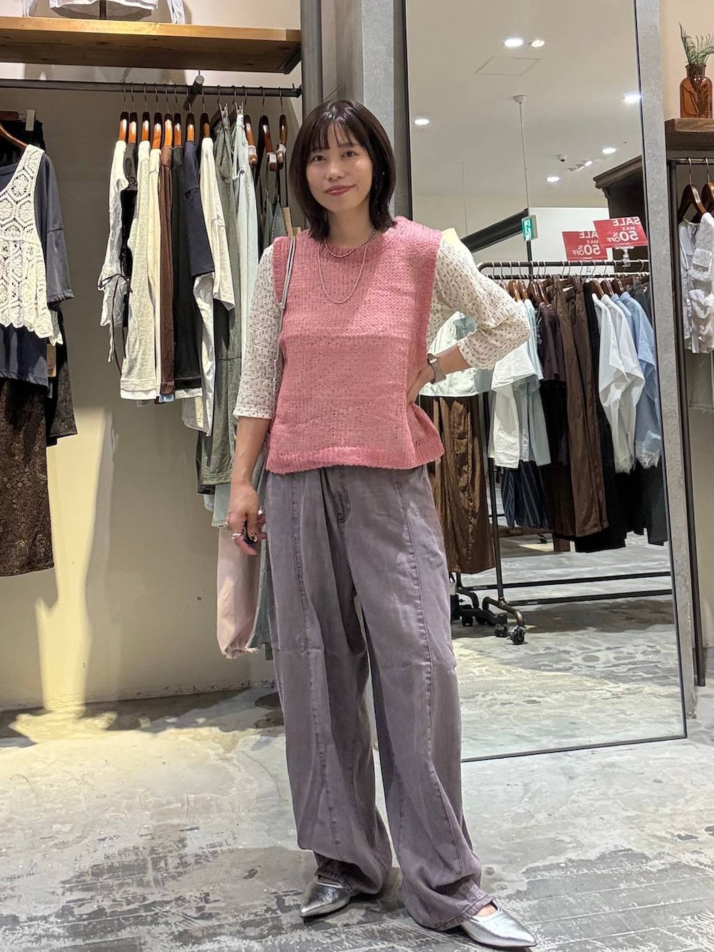 ピンク系のベスト、ベージュ系のTシャツ/カットソー、パープル系のデニムパンツを着用したレディースの夏コーディネートの3枚目の写真
