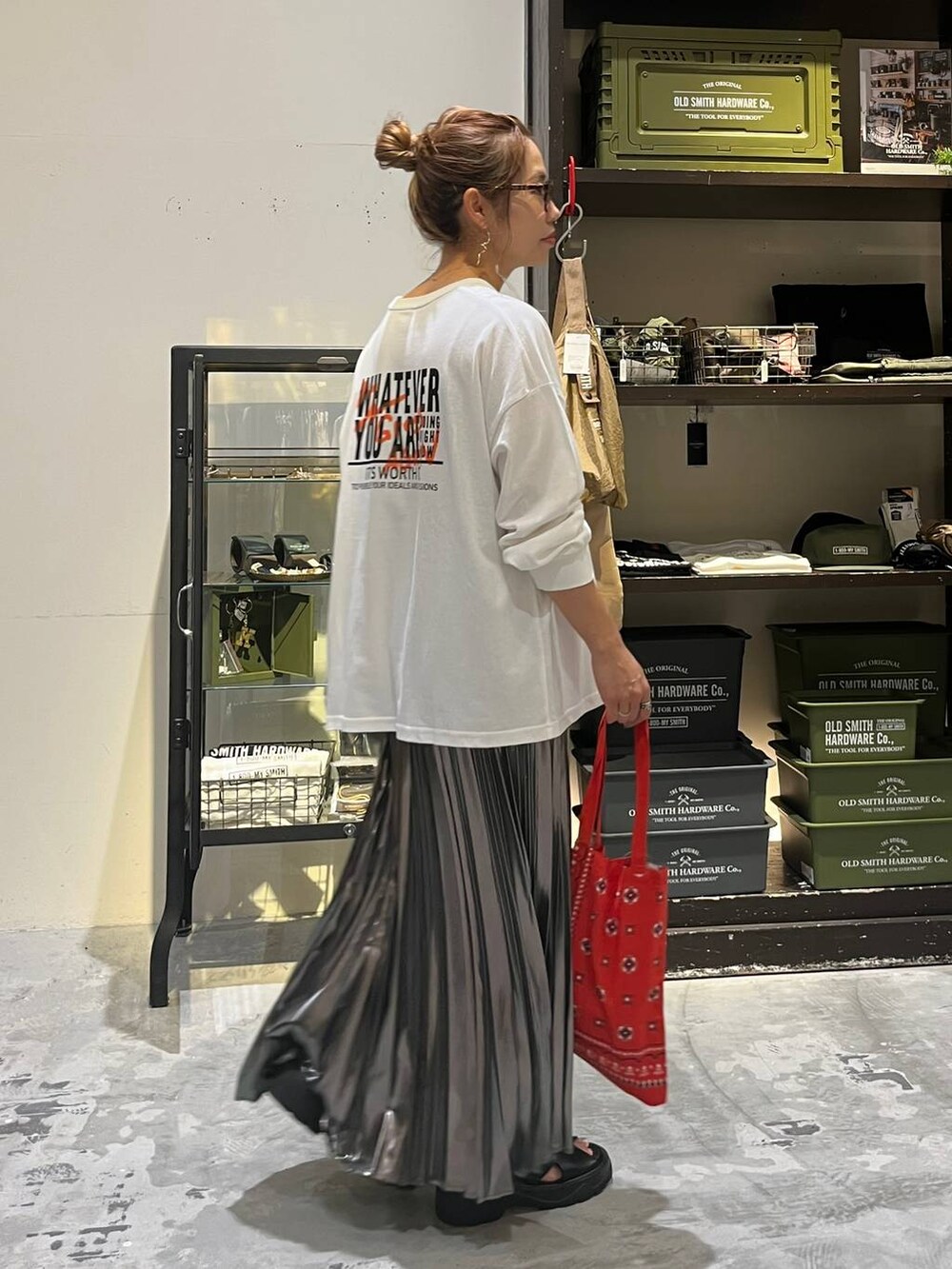 ブラック系のサンダル、ホワイト系のTシャツ/カットソー、レッド系のトートバッグを着用したレディースの夏コーディネートの3枚目の写真