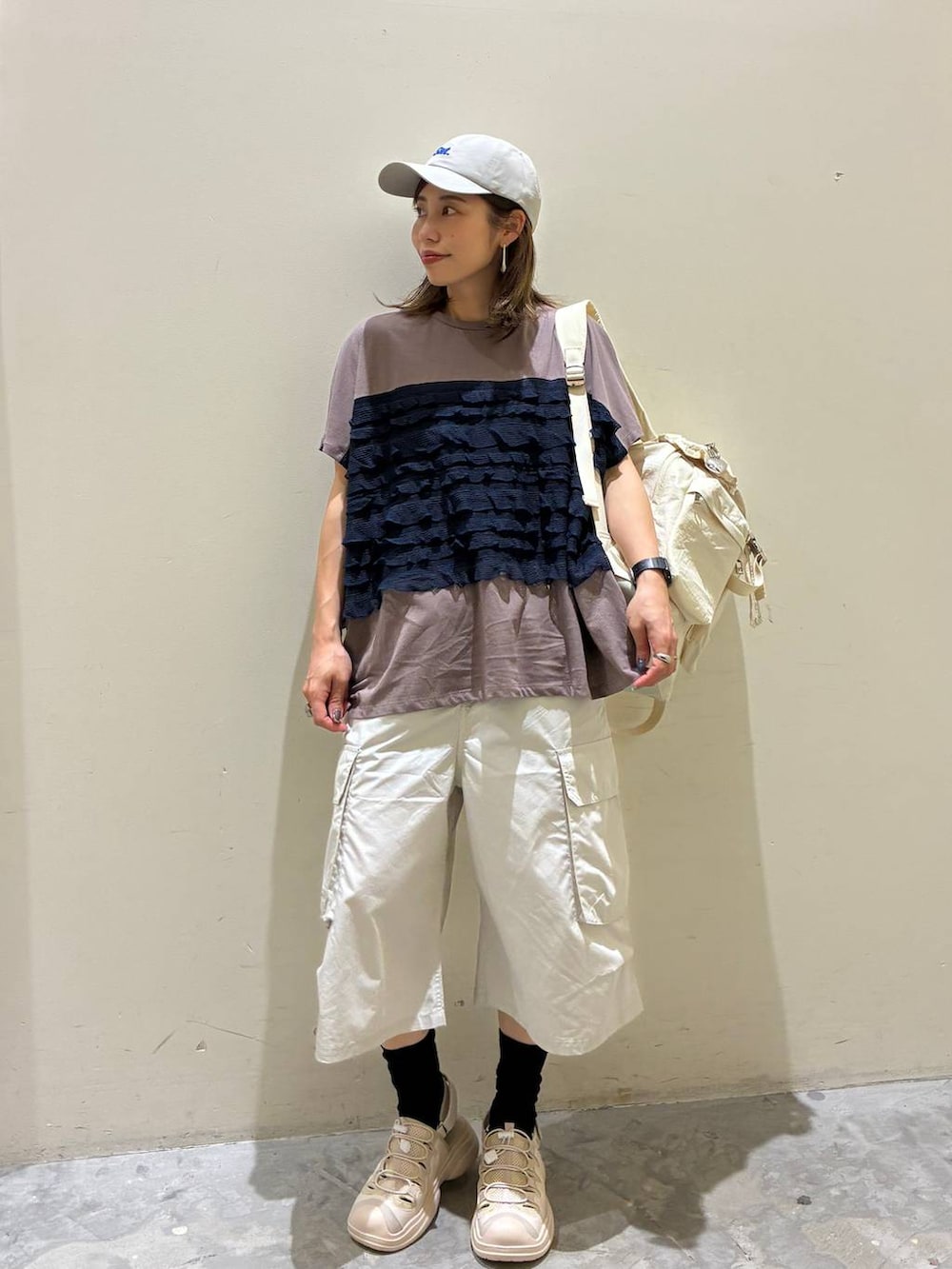 ベージュ系のバックパック/リュック、ベージュ系のサンダル、グレー系のその他パンツを着用したレディースの夏コーディネートの2枚目の写真