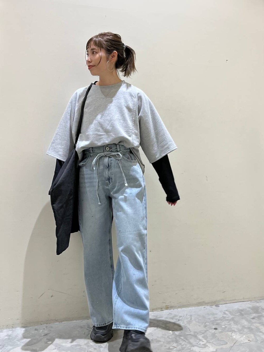 グレー系のトートバッグ、グレー系のTシャツ/カットソー、ブルー系のデニムパンツを着用したレディースの春コーディネートの6枚目の写真