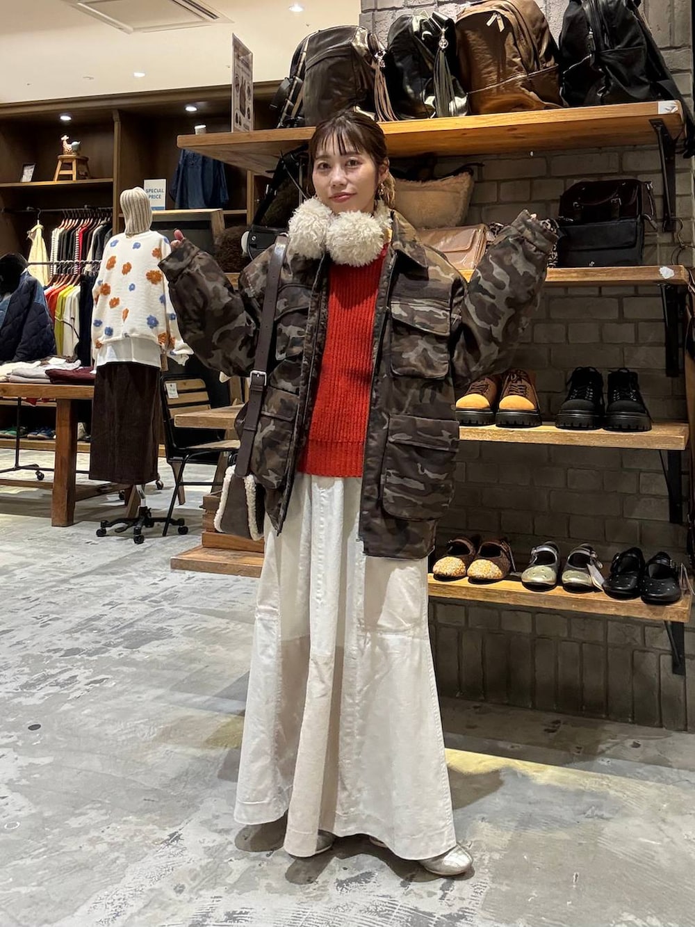 ゴールド系のスニーカー、ブラウン系のショルダーバッグ、レッド系のニット/セーターを着用したレディースの秋コーディネートの4枚目の写真