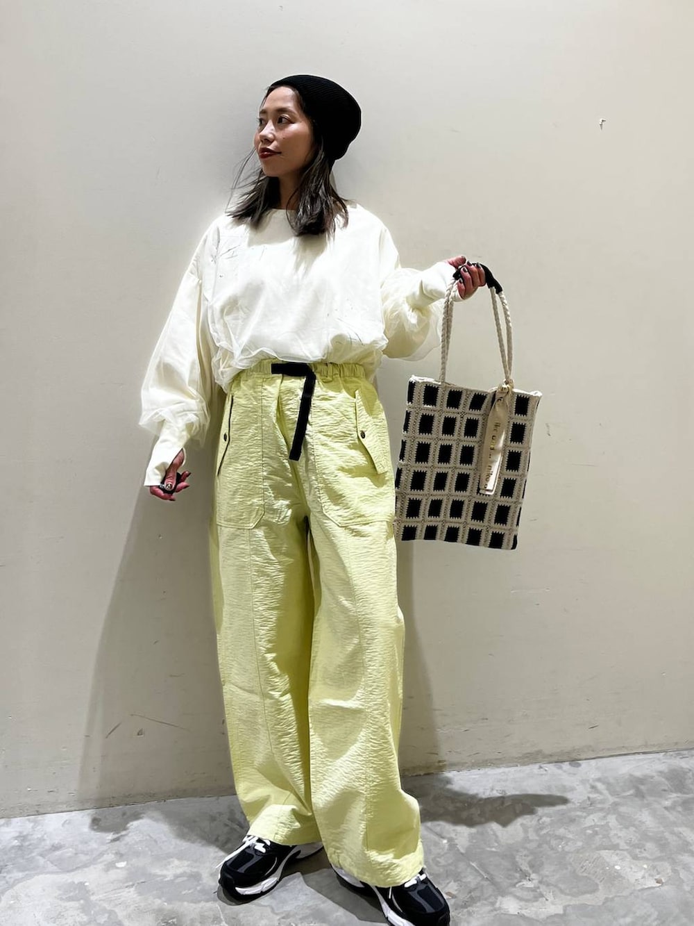 ホワイト系のスウェット、ブラック系のトートバッグ、ブラック系のスニーカーを着用したレディースの春コーディネートの4枚目の写真