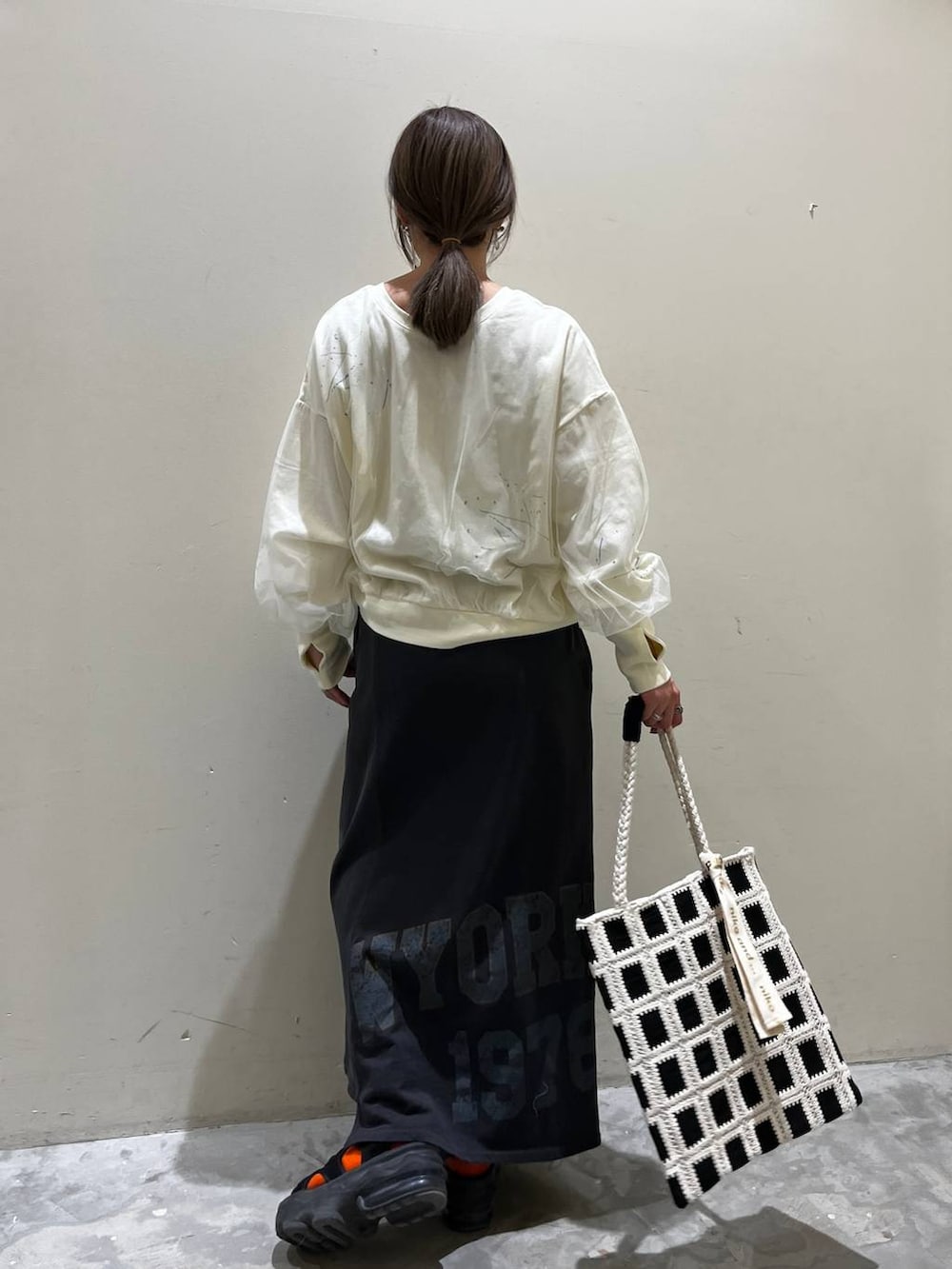 ホワイト系のスウェット、ブラック系のトートバッグ、その他のスカートを着用したレディースの春コーディネートの4枚目の写真