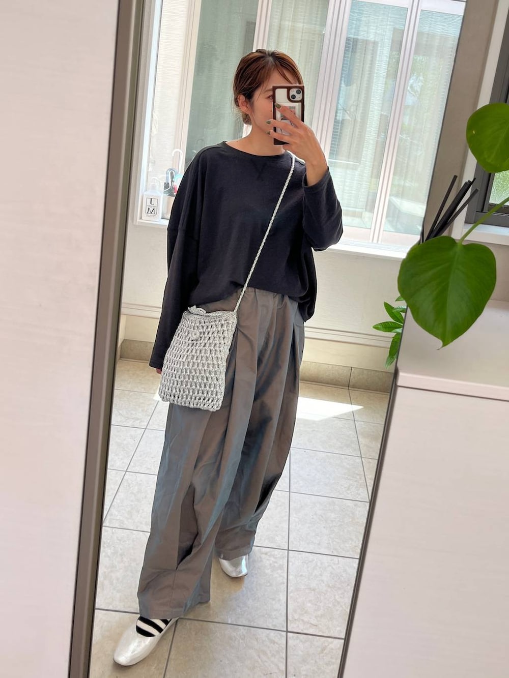 グレー系のショルダーバッグ、シルバー系のパンプス、グリーン系のチノパンツを着用したレディースの夏コーディネートの3枚目の写真