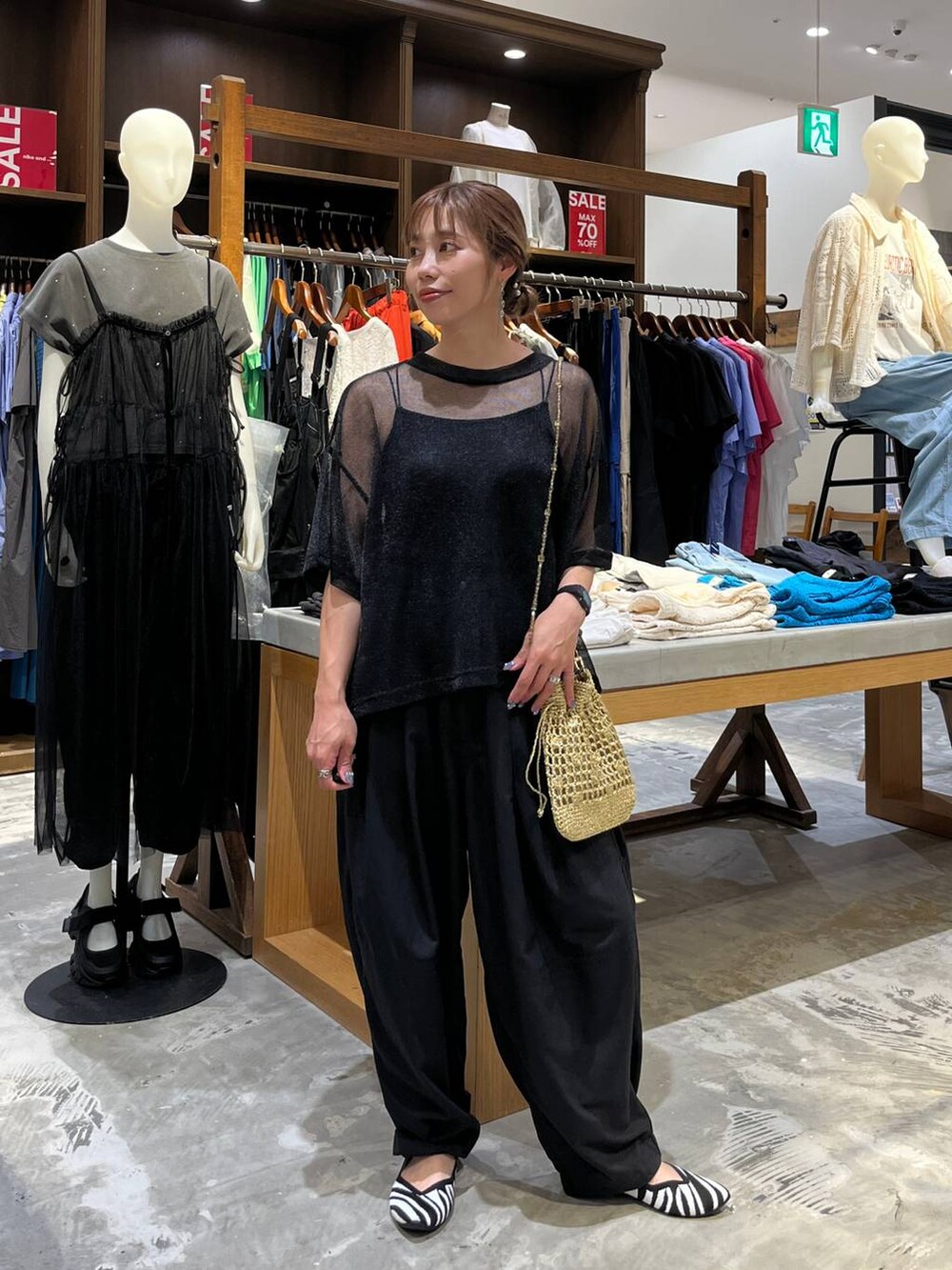 イエロー系のショルダーバッグ、ブラック系のその他パンツ、その他のパンプスを着用したレディースの夏コーディネートの2枚目の写真