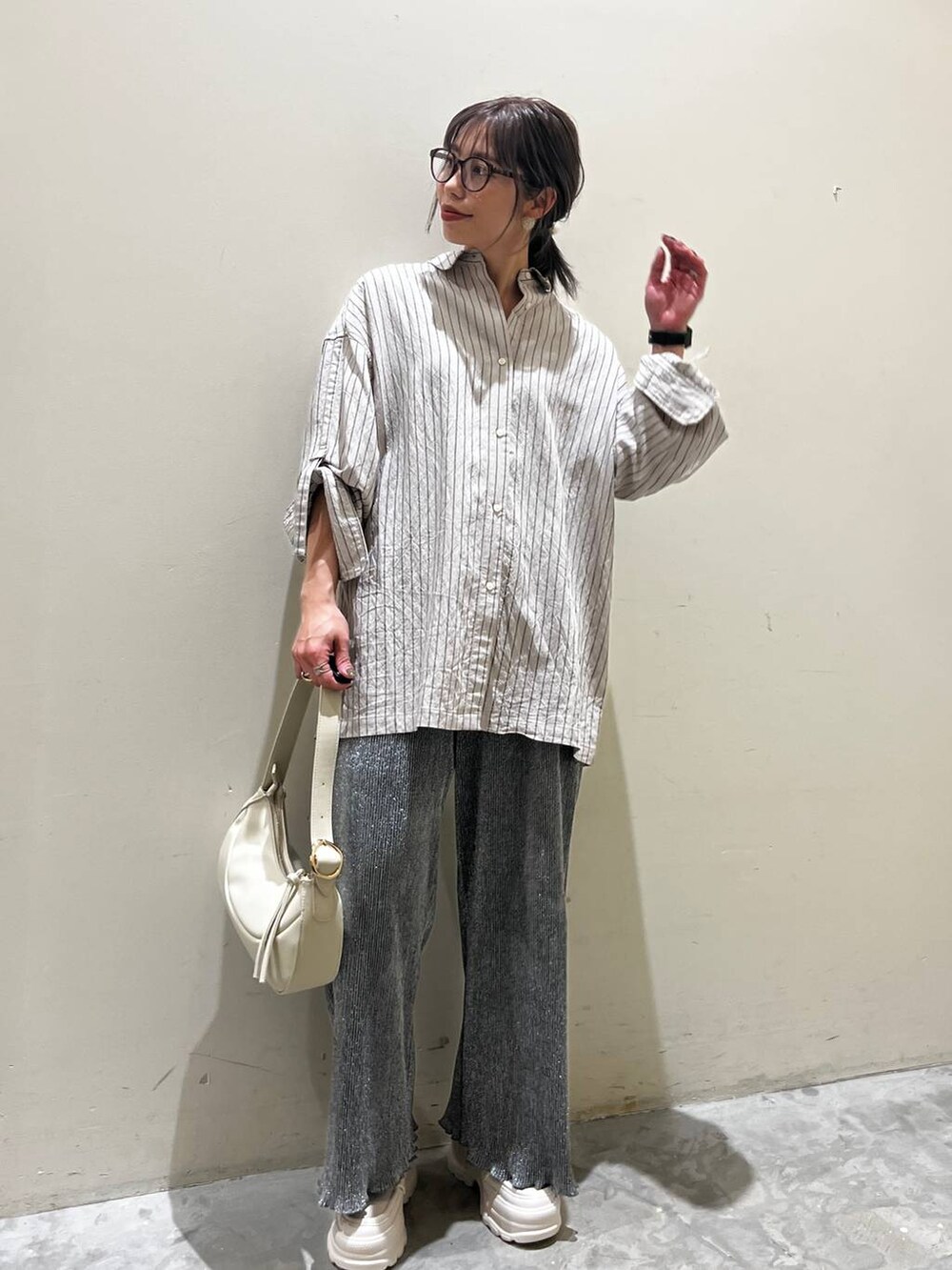 ベージュ系のショルダーバッグ、ベージュ系のローファー、グレー系のその他パンツを着用したレディースの春コーディネートの2枚目の写真
