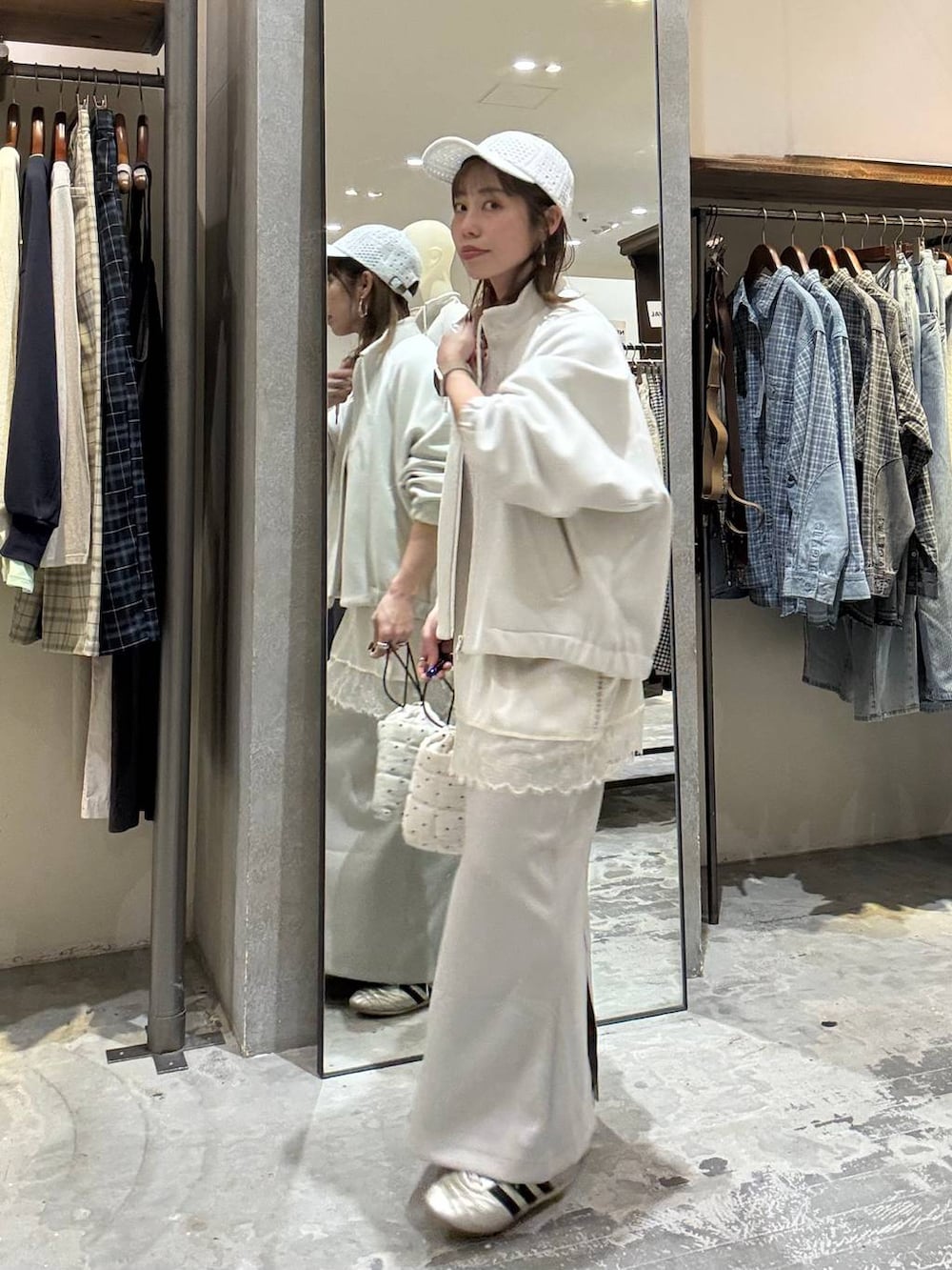 ゴールド系のスニーカー、ホワイト系のショルダーバッグ、ベージュ系のブルゾンを着用したレディースの春コーディネートの6枚目の写真