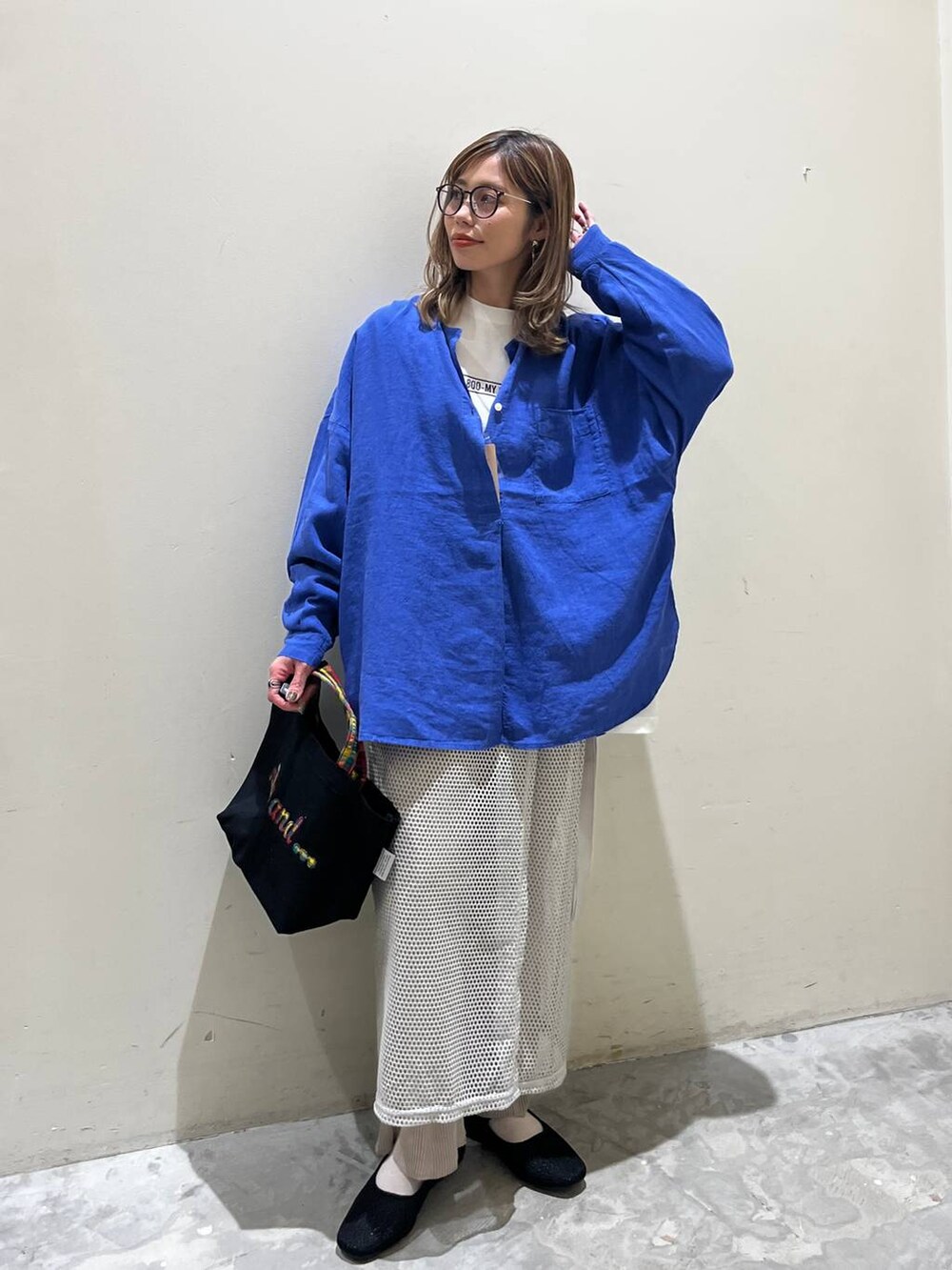 グレー系のスカート、ブラック系のその他シューズ、ブラック系のトートバッグを着用したレディースの春コーディネートの6枚目の写真