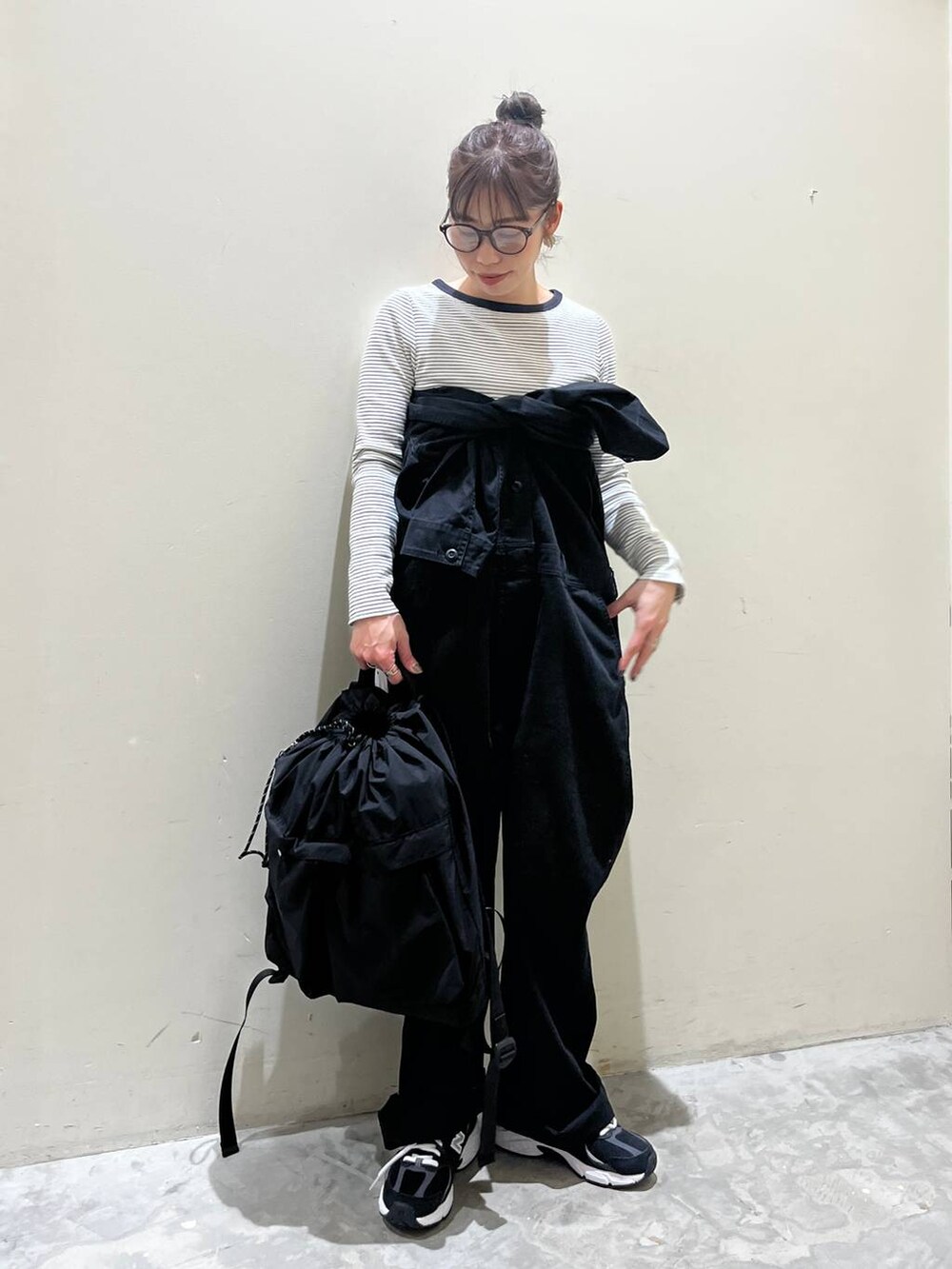 ブラック系のバックパック/リュック、ベージュ系のTシャツ/カットソー、ブラック系のつなぎ/オールインワンを着用したレディースの春コーディネートの3枚目の写真