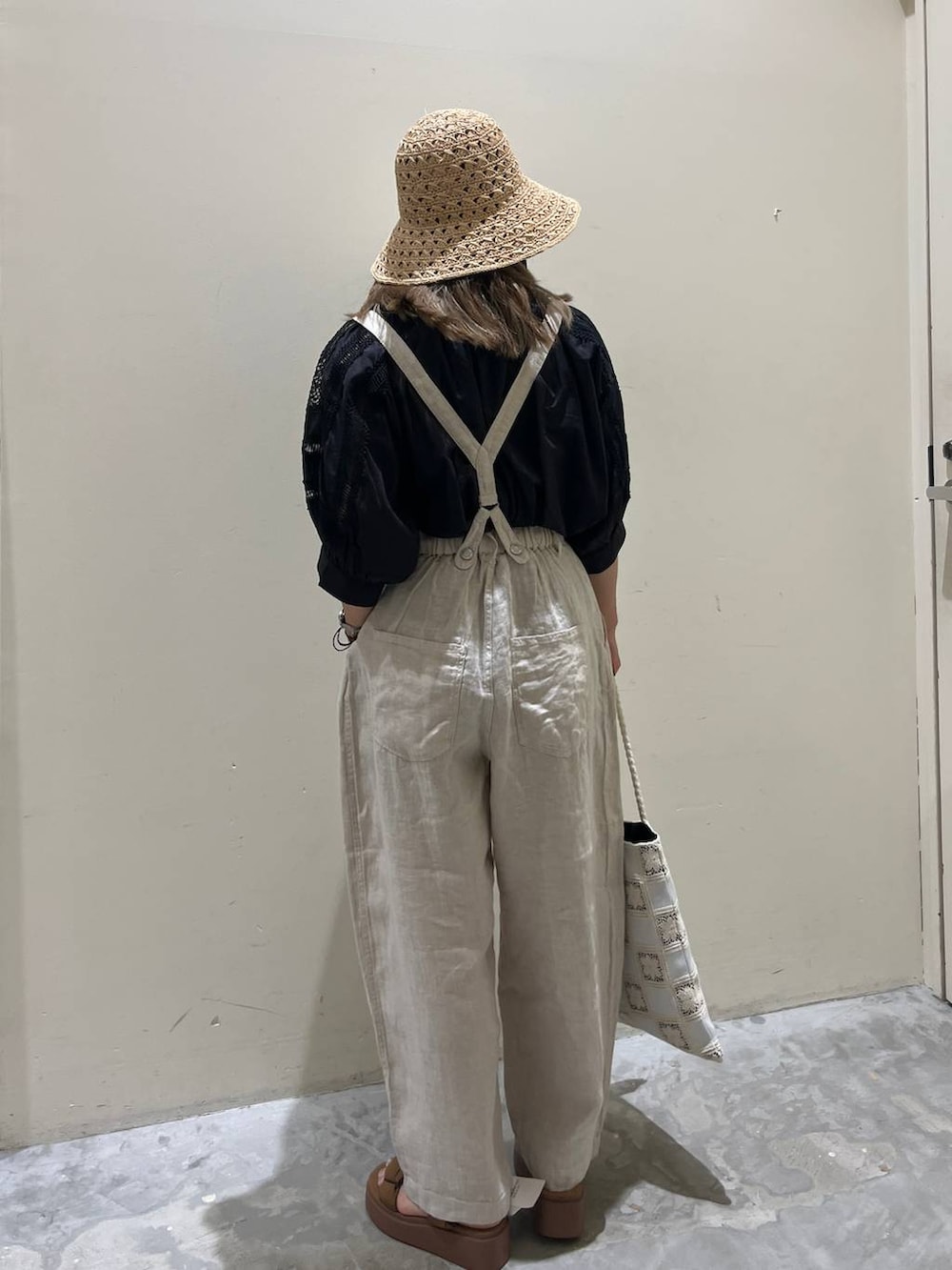 イエロー系のサンダル、ベージュ系のその他パンツ、ホワイト系のトートバッグを着用したレディースの春コーディネートの4枚目の写真