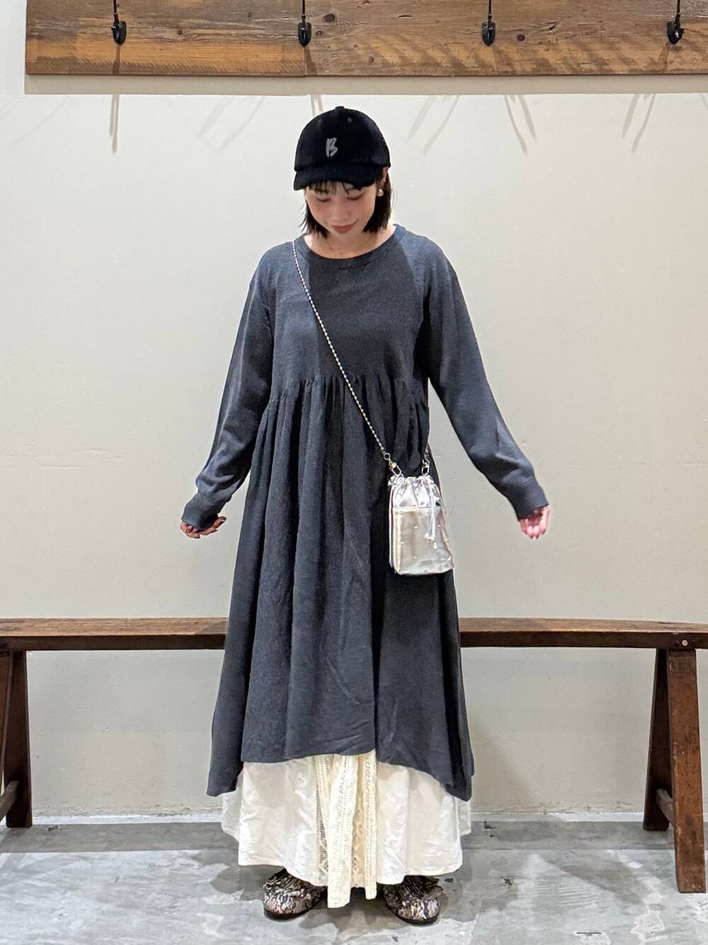 シルバー系のショルダーバッグ、グレー系のワンピース、ベージュ系のスカートを着用したレディースの秋コーディネートの4枚目の写真