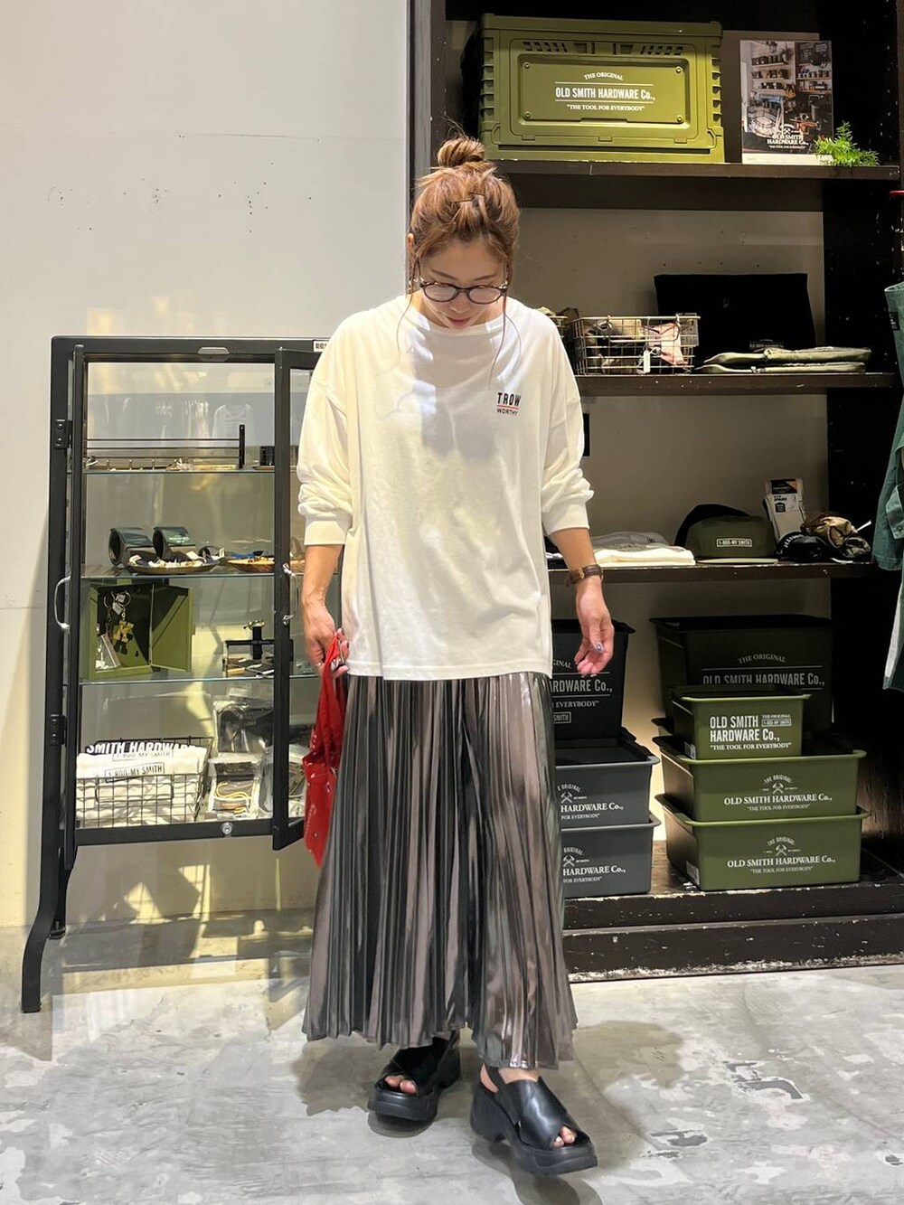 ブラック系のサンダル、ホワイト系のTシャツ/カットソー、レッド系のトートバッグを着用したレディースの夏コーディネートの6枚目の写真