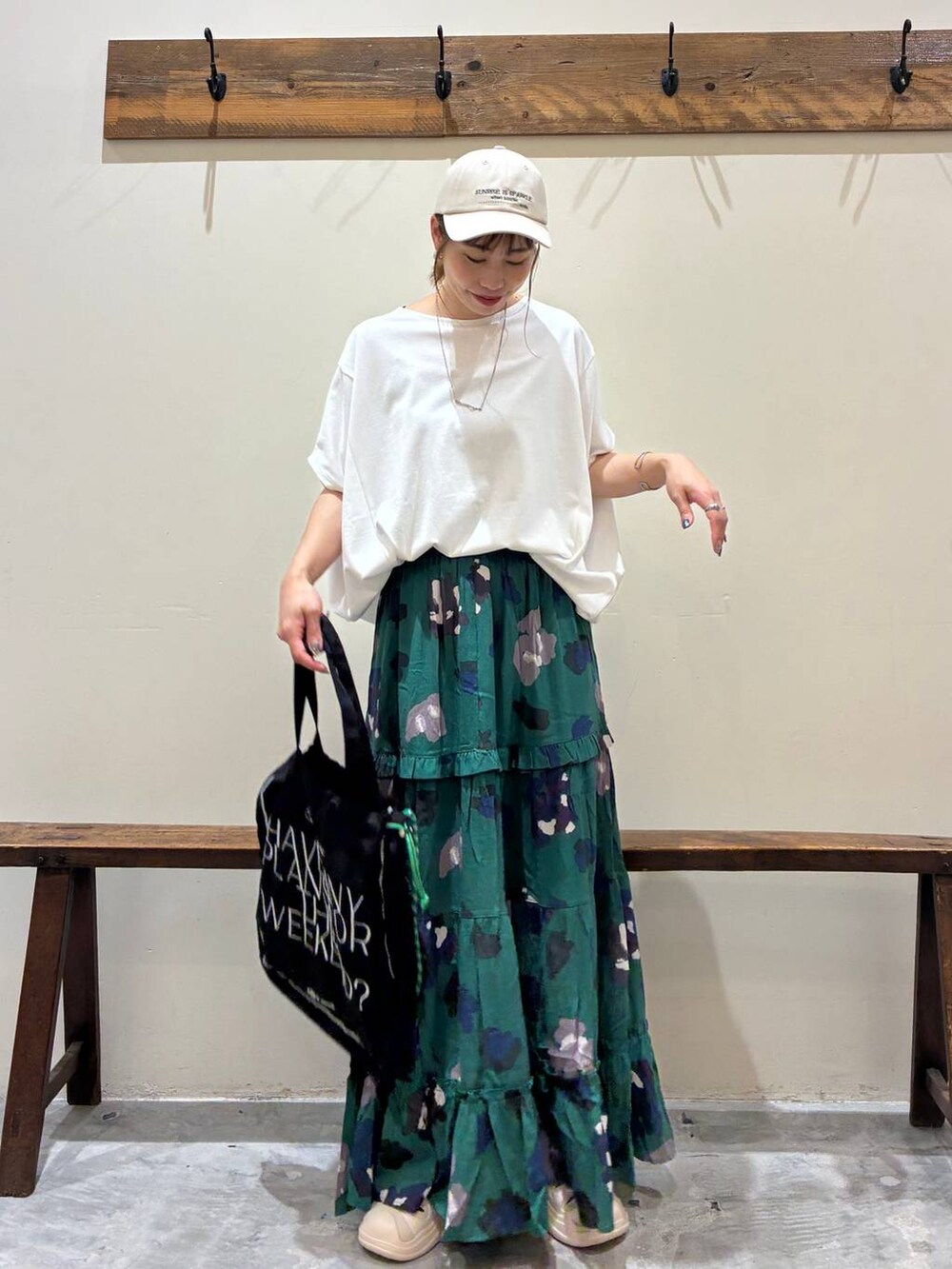 ブラック系のトートバッグ、グリーン系のスカート、ベージュ系のサンダルを着用したレディースの夏コーディネートの9枚目の写真