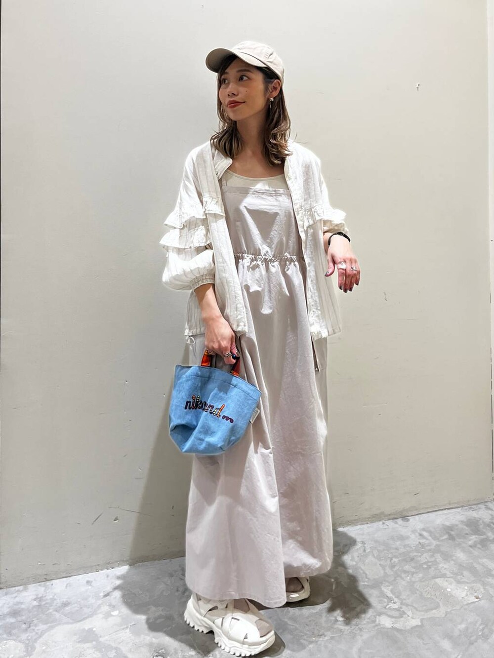 ベージュ系のワンピース、ベージュ系のサンダル、ベージュ系のシャツ/ブラウスを着用したレディースの春コーディネートの7枚目の写真