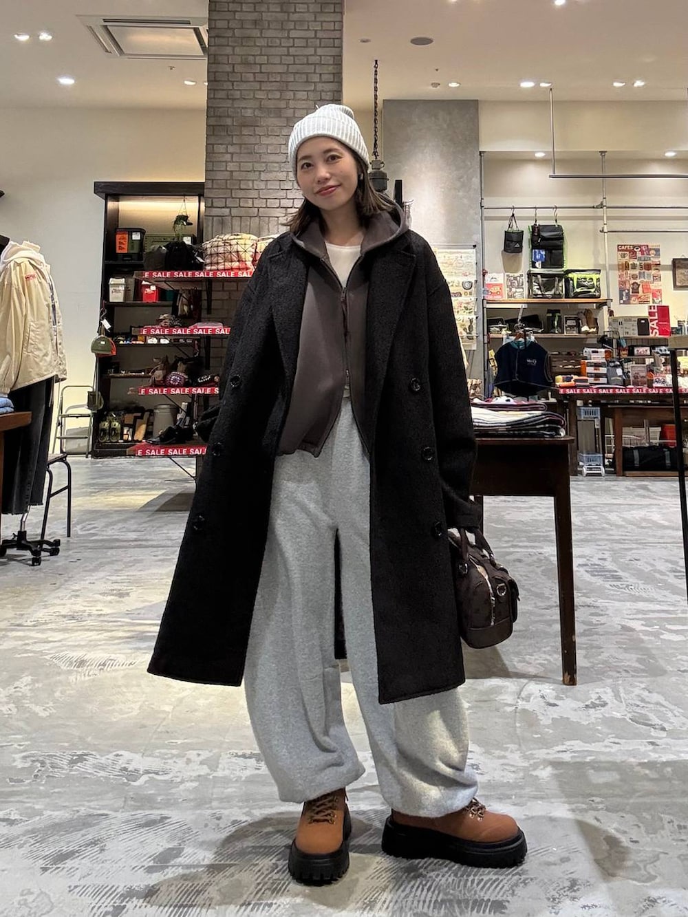 ブラウン系のボストンバッグ、ブラウン系のダウンジャケット/コート、イエロー系のその他シューズを着用したレディースの冬コーディネートの5枚目の写真