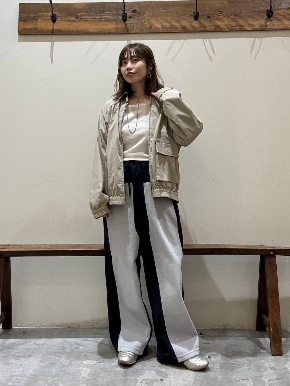 ゴールド系のスニーカー、ブルー系のデニムパンツ、イエロー系のブルゾンを着用したレディースの冬コーディネートの3枚目の写真